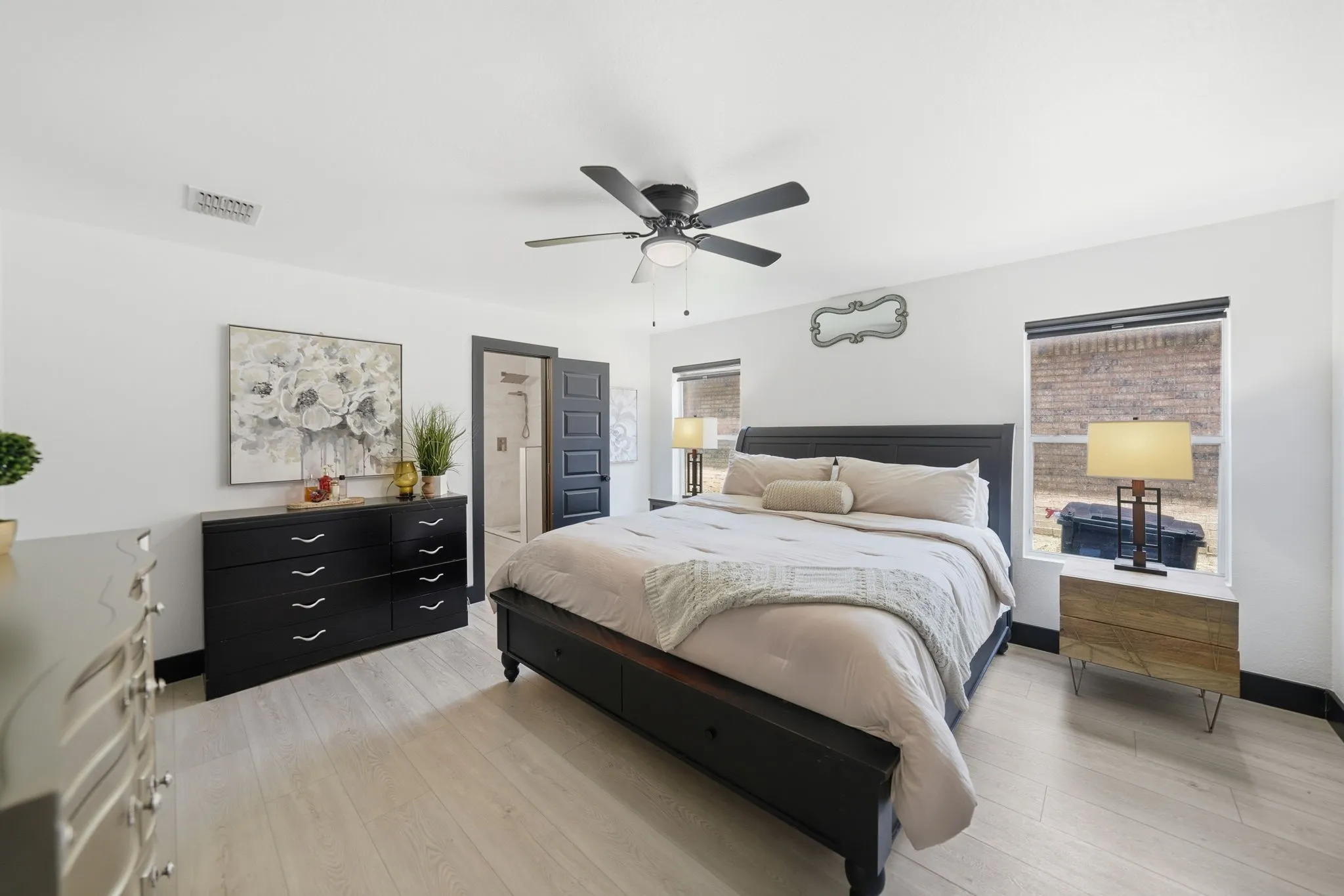 Spacious room featuring light wood-finish flooring, white walls, and a dark accent trim