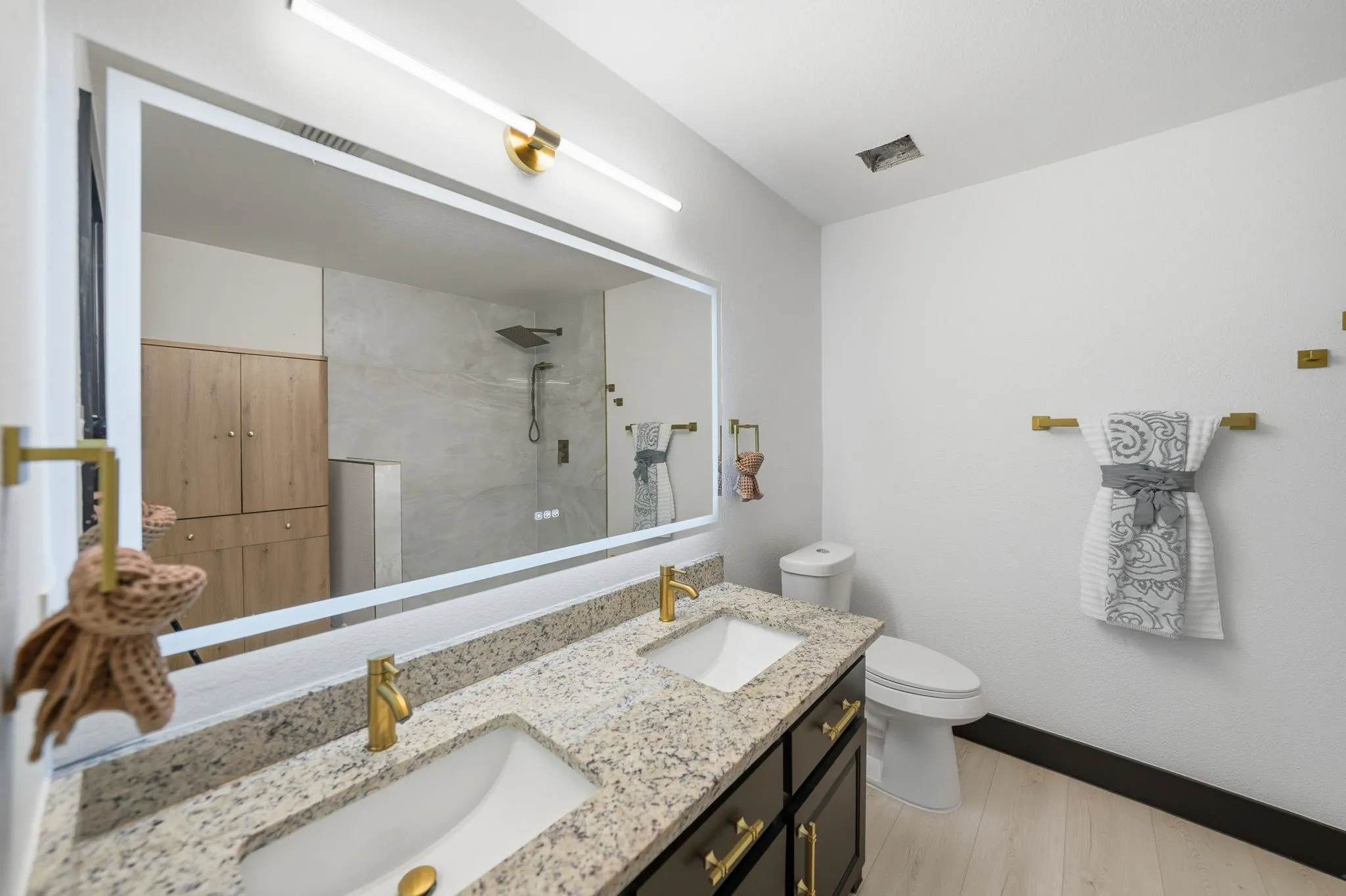 Dual vanity with speckled stone countertop and undermount sinks