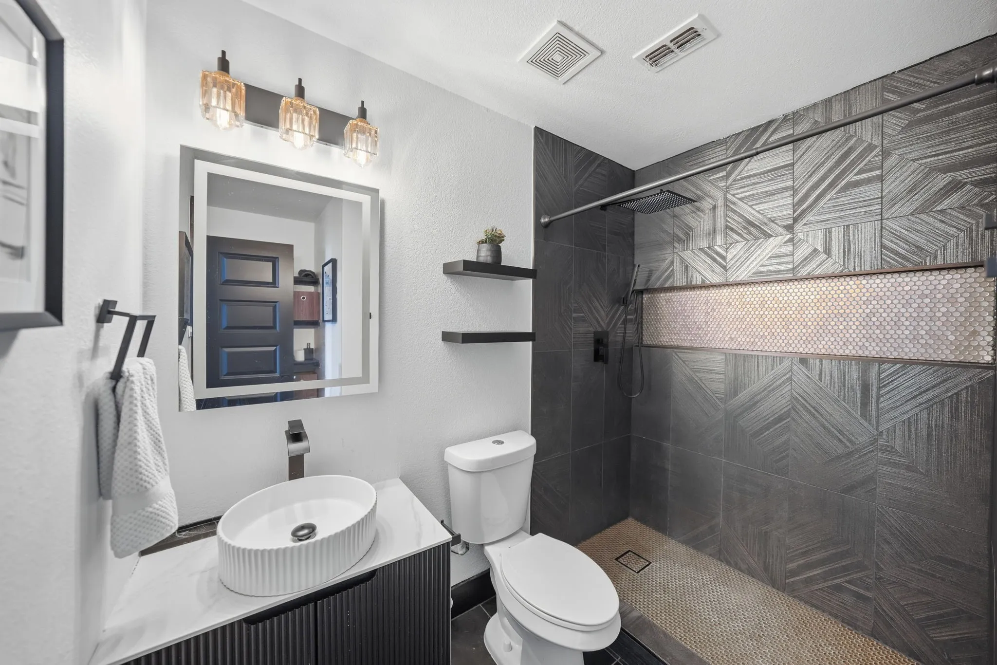 Contemporary bathroom featuring a walk-in shower with patterned wall tile and a mosaic accent band