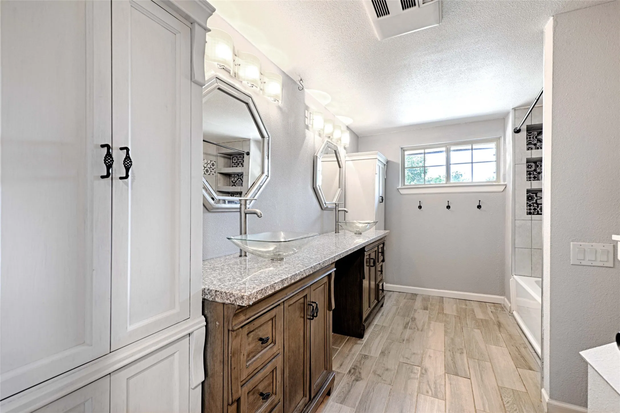 Bathroom featuring dual vanity with granite countertops and vessel sinks