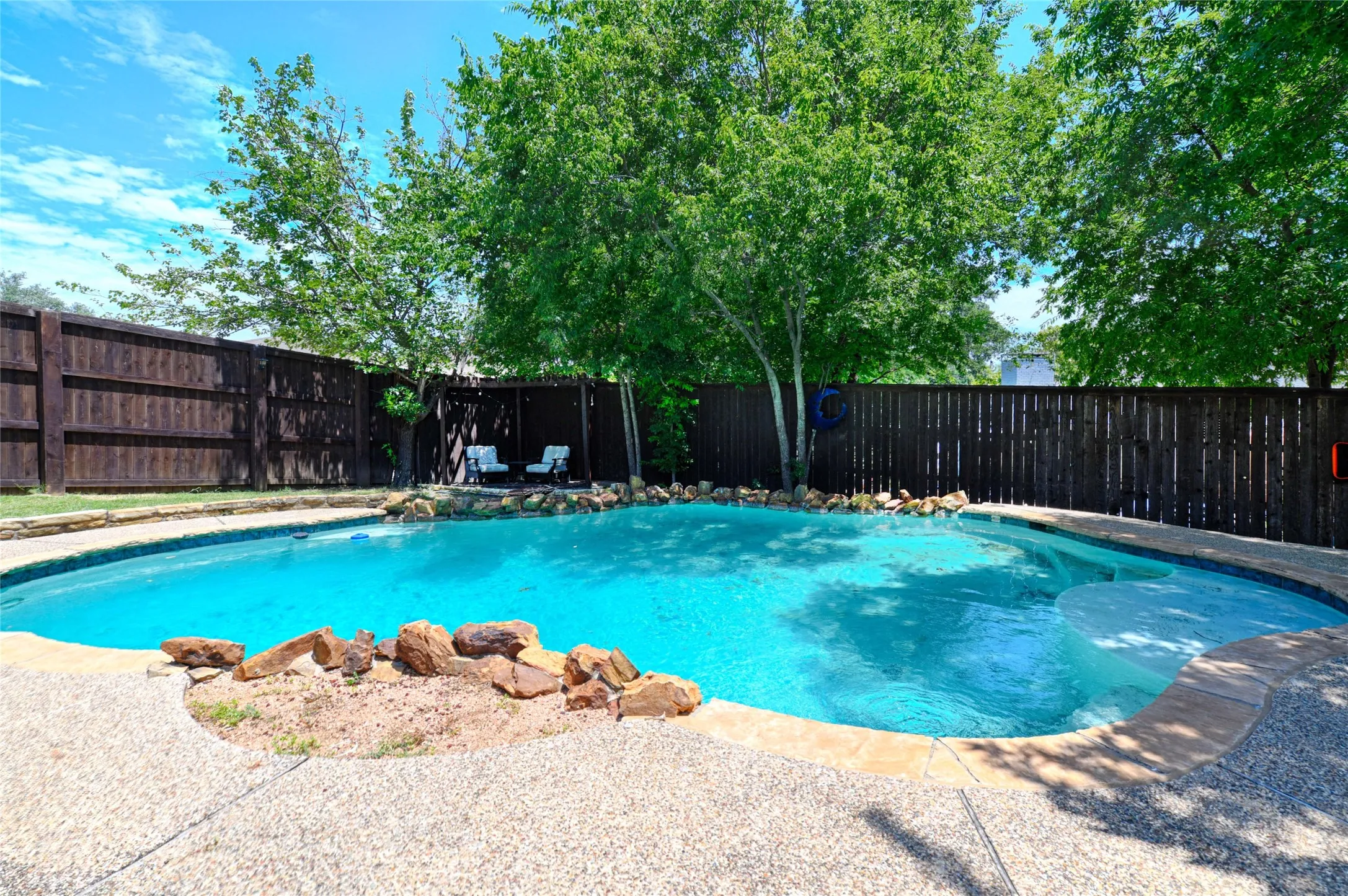 Resort-style pool with integrated spa and rock accents