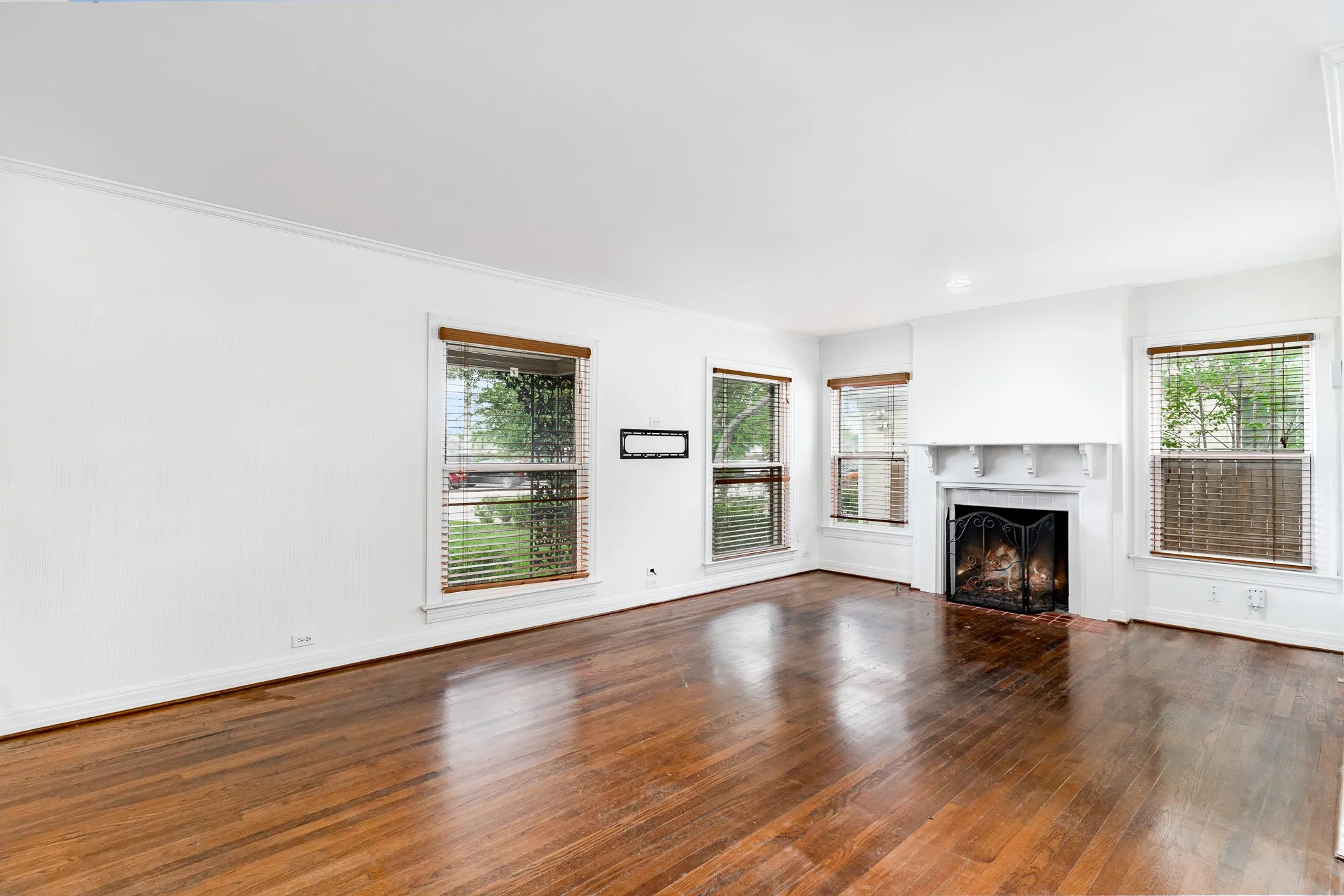 Unfurnished living room featuring baseboards, dark wood-style floors, and a fireplace