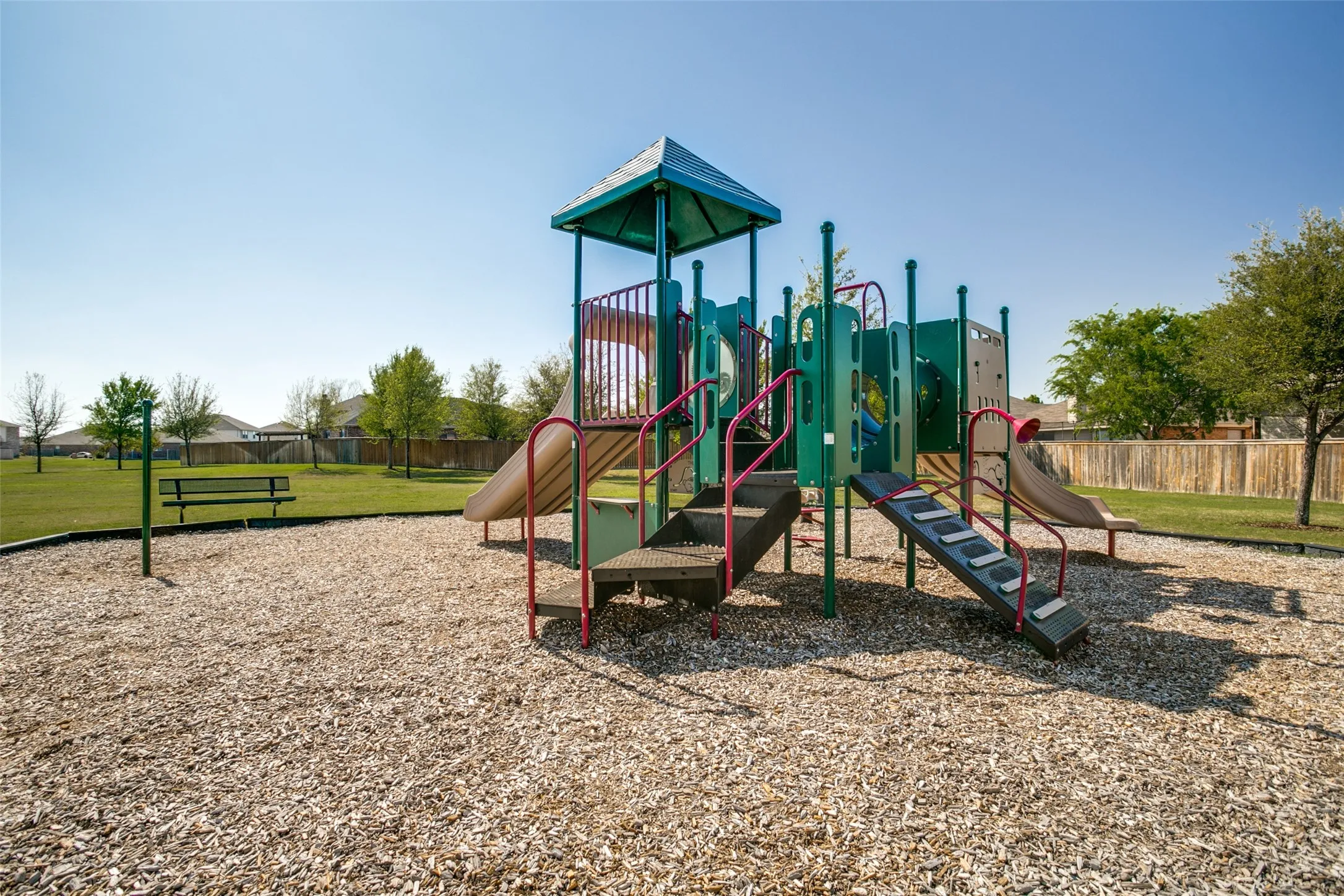 Community playground with multiple slides, climbing elements, and a covered platform