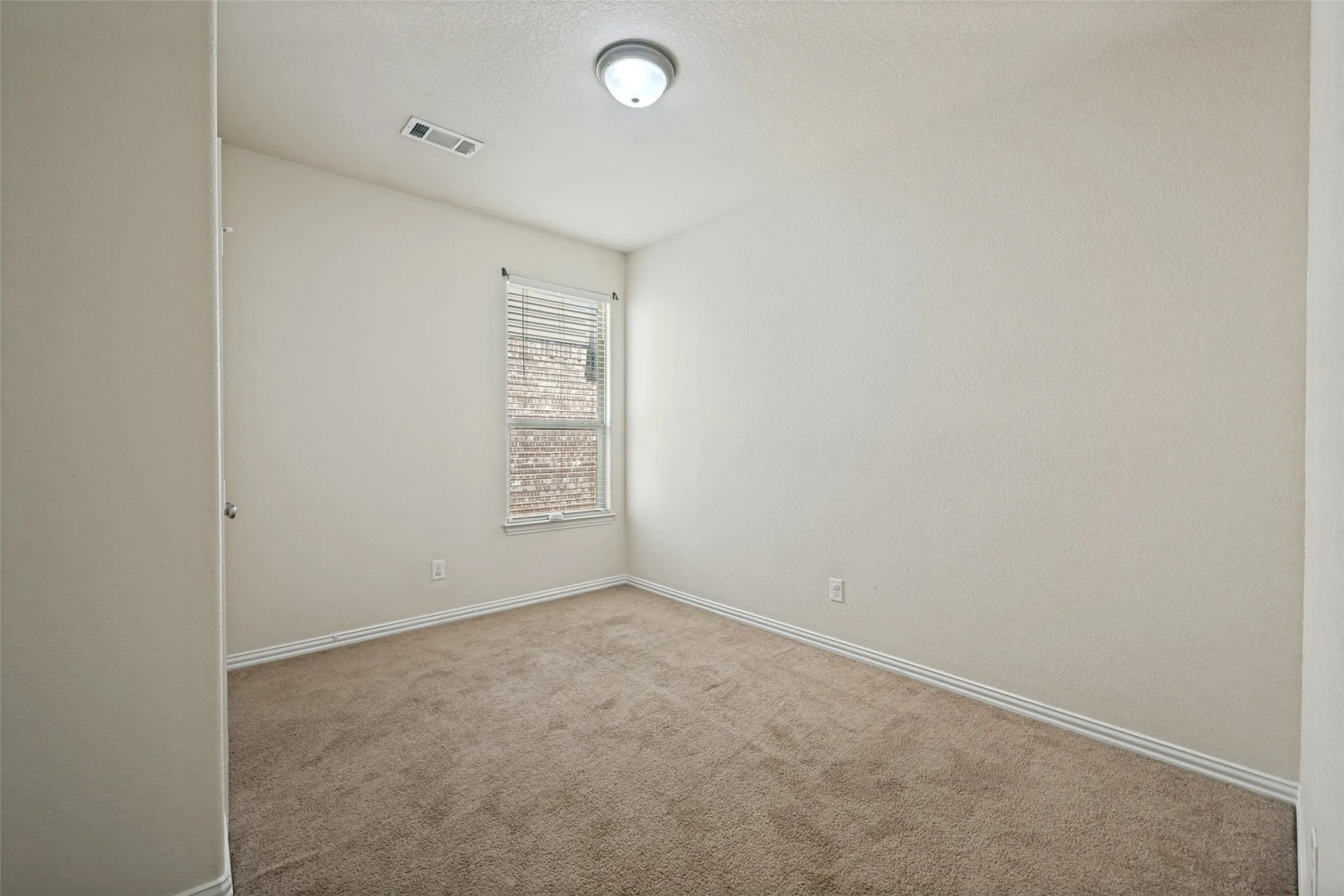 Neutral tone wall colors with white baseboards frame a carpeted floor