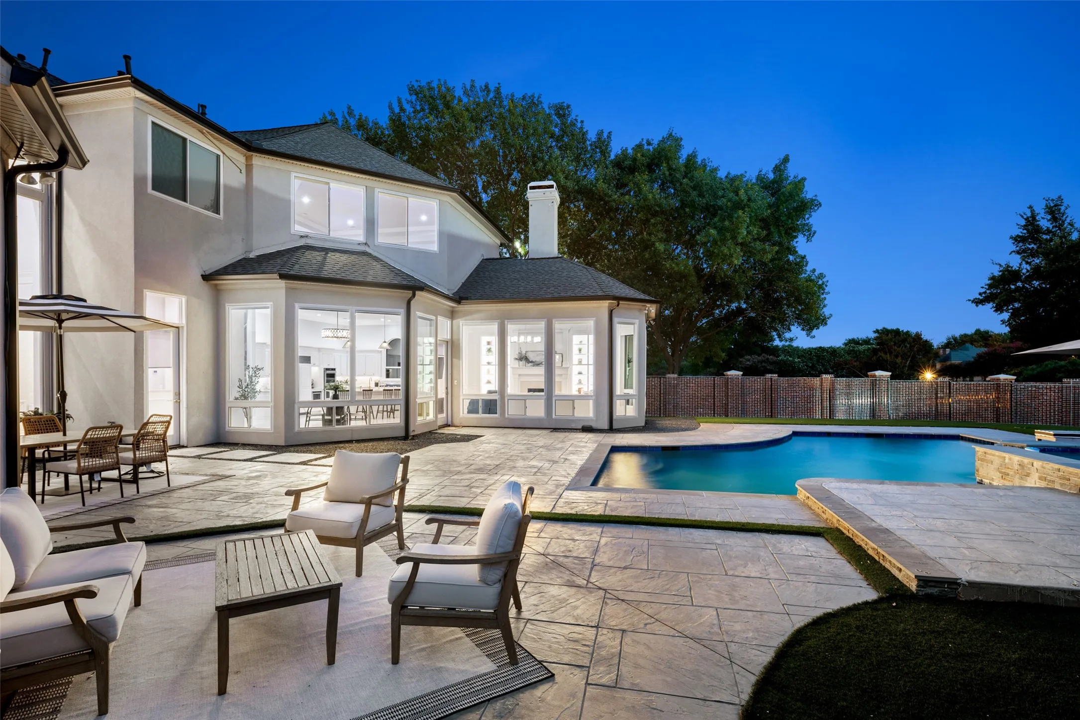 Walls of windows connect the interior to an incredible outdoor setting featuring a resort-inspired pool, generous entertaining spaces, and maintenance-free turf designed for year-round enjoyment.