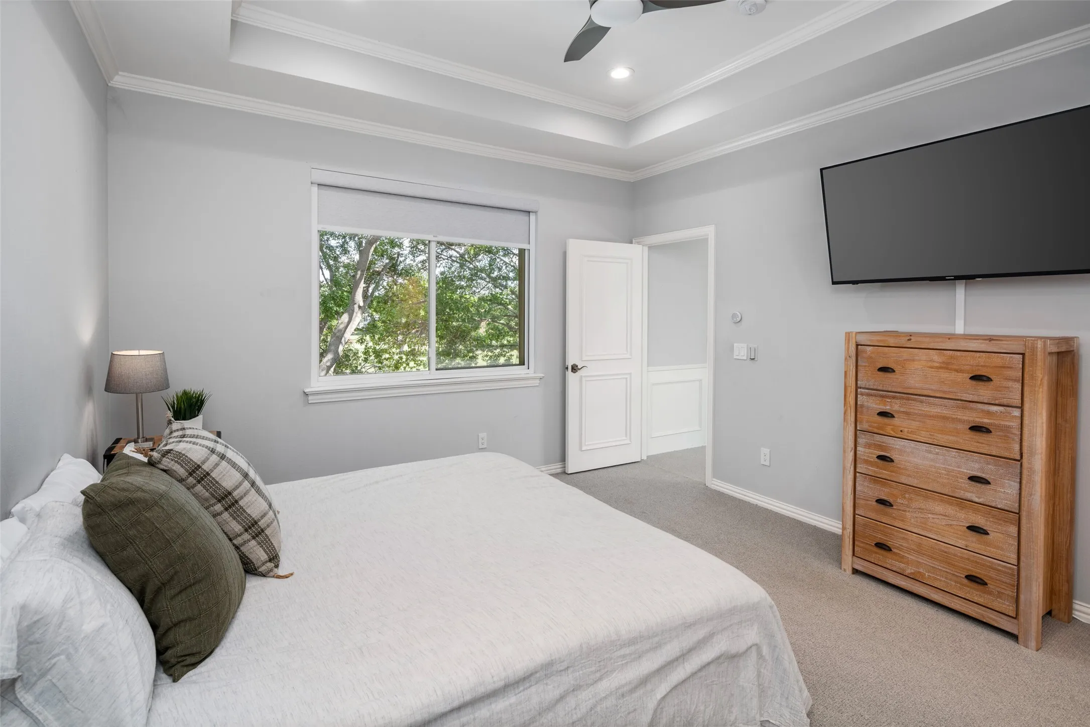 Generously sized secondary bedroom features tray ceilings, abundant natural light, neutral finishes, and ample space for guests or family while offering comfort and flexibility.