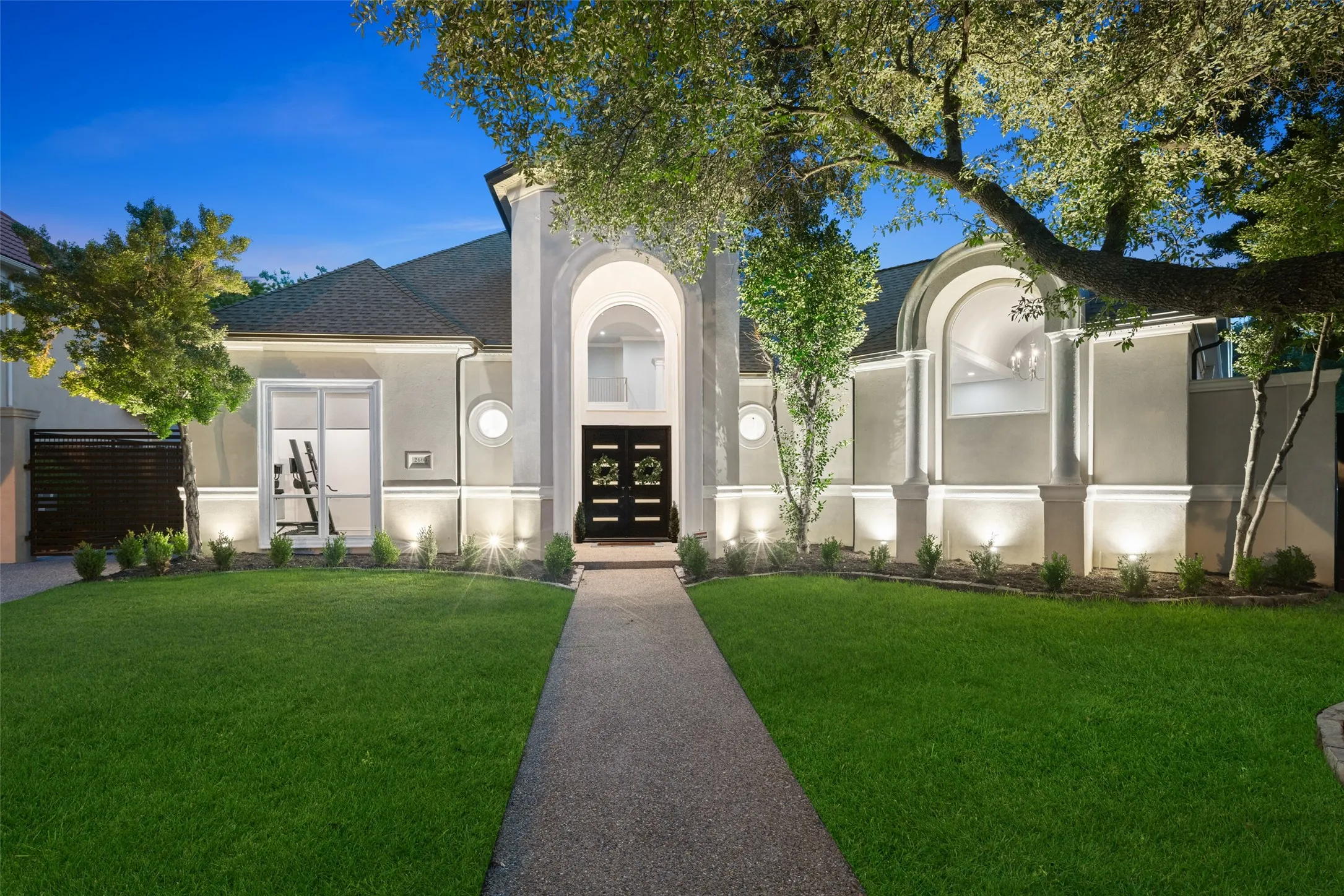A striking first impression begins with timeless architecture. As evening falls, professional landscape lighting highlights the architectural details, creating a warm and inviting presence. The illuminated entry and mature trees make this home as impressive after sunset as it is during the day.