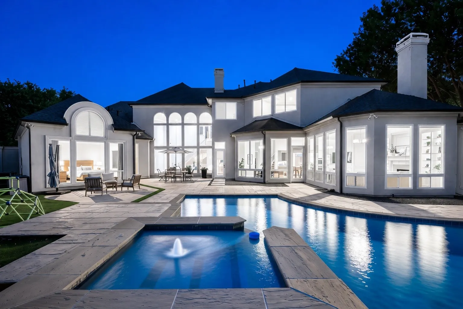 A resort-style pool with elevated spa anchors this exceptional backyard. Surrounded by expansive patios and lush turf, the outdoor space offers both relaxation and plenty of room for entertaining.
