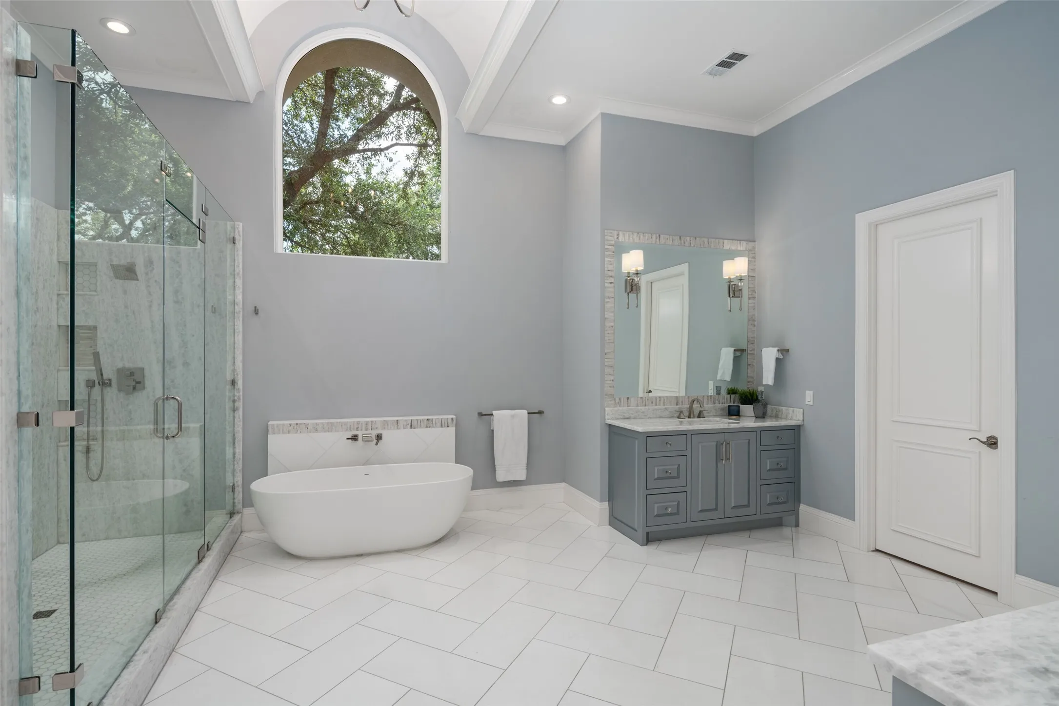 Luxurious owner's bath showcases oversized dual vanities, elegant marble finishes, soaking tub, expansive walk-in shower, and thoughtfully designed space that blends beauty with everyday functionality.