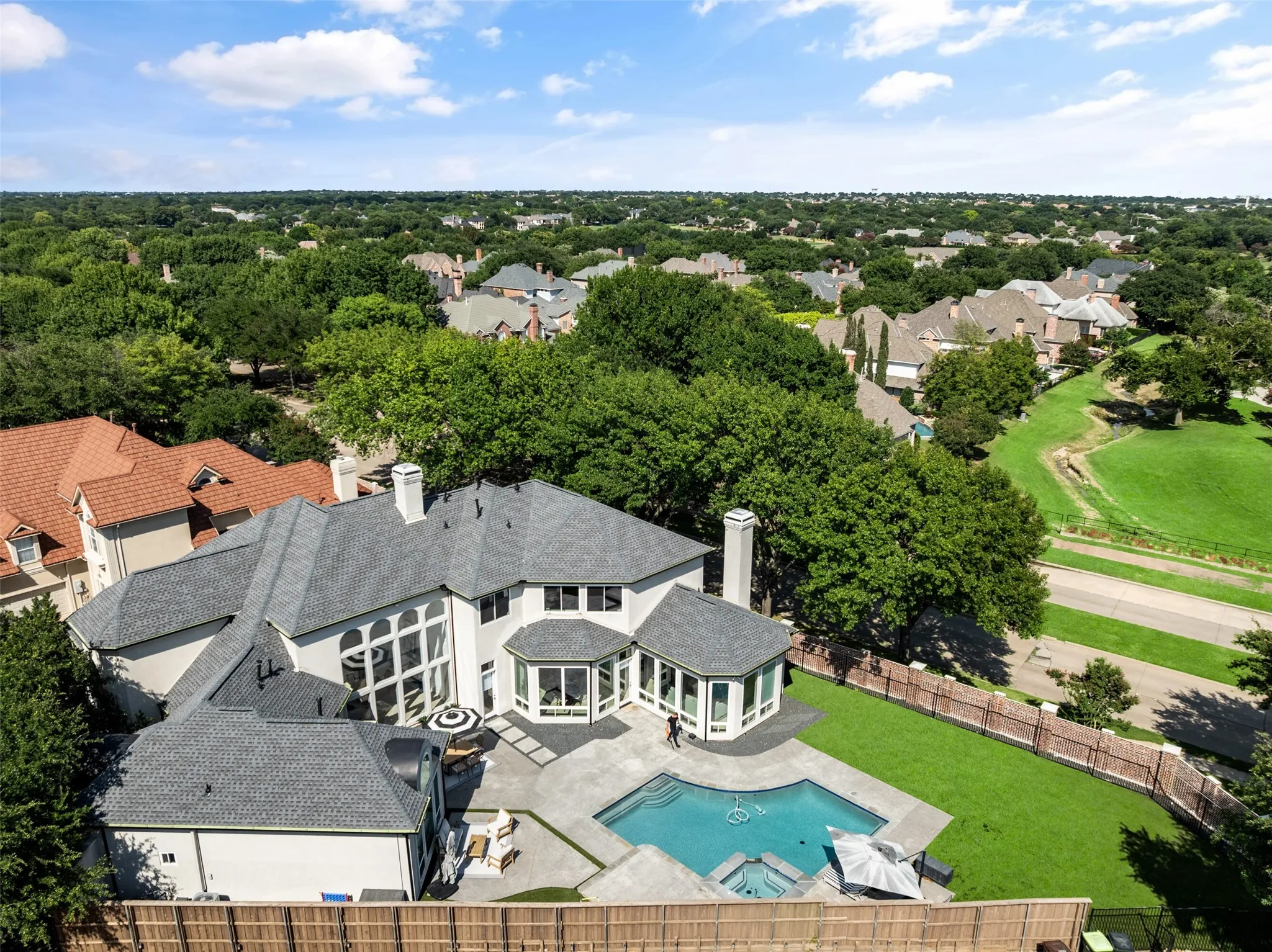 Rear aerial highlights the beautifully landscaped backyard with pool, spa, and generous outdoor living spaces.