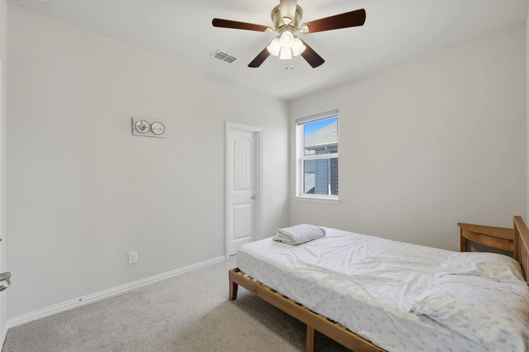Carpeted room featuring a ceiling fan with integrated lighting, a window with exterior views, and a paneled interior door