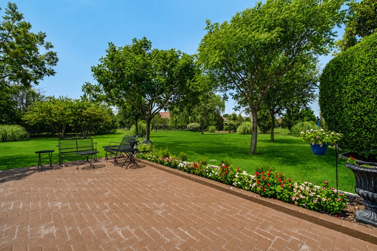 Additional seating area by the back lawn, with large grass space for pets and play. Located beyond the gated driveway.