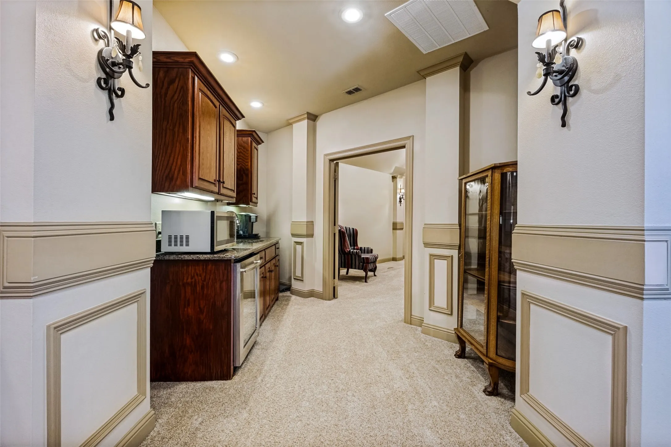 Wet bar featuring wood cabinetry, granite countertop, and integrated beverage cooler