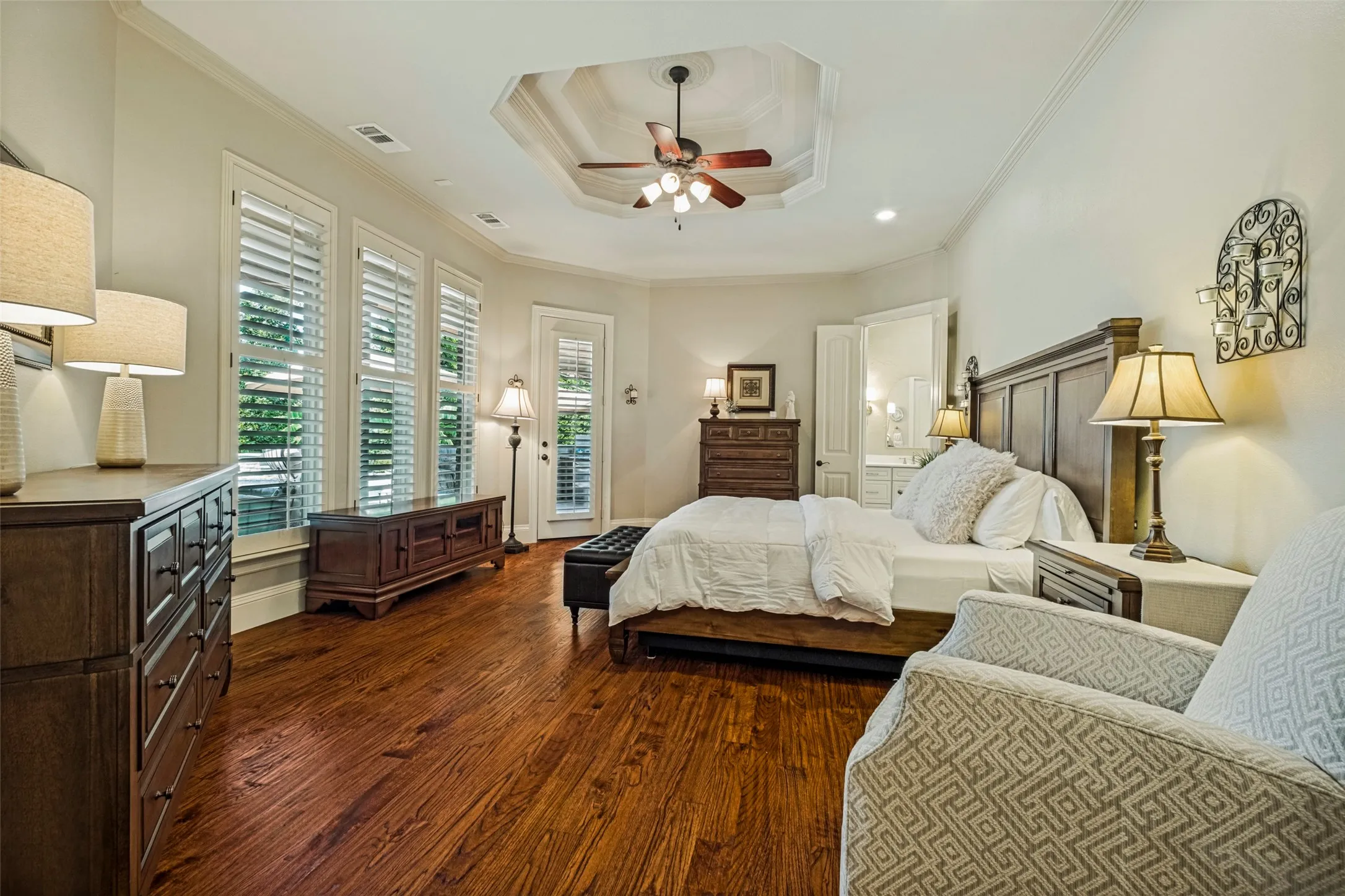 Wood-finish flooring with a tray ceiling and ceiling fan