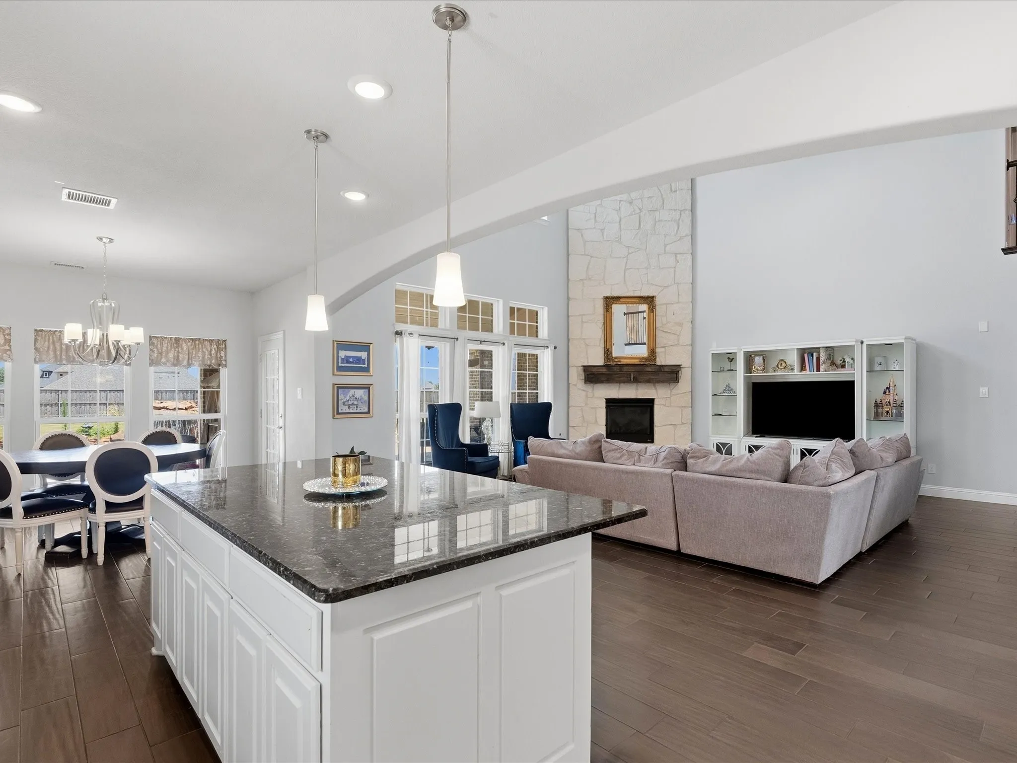 View from kitchen of living area with soaring stone gas log fireplace