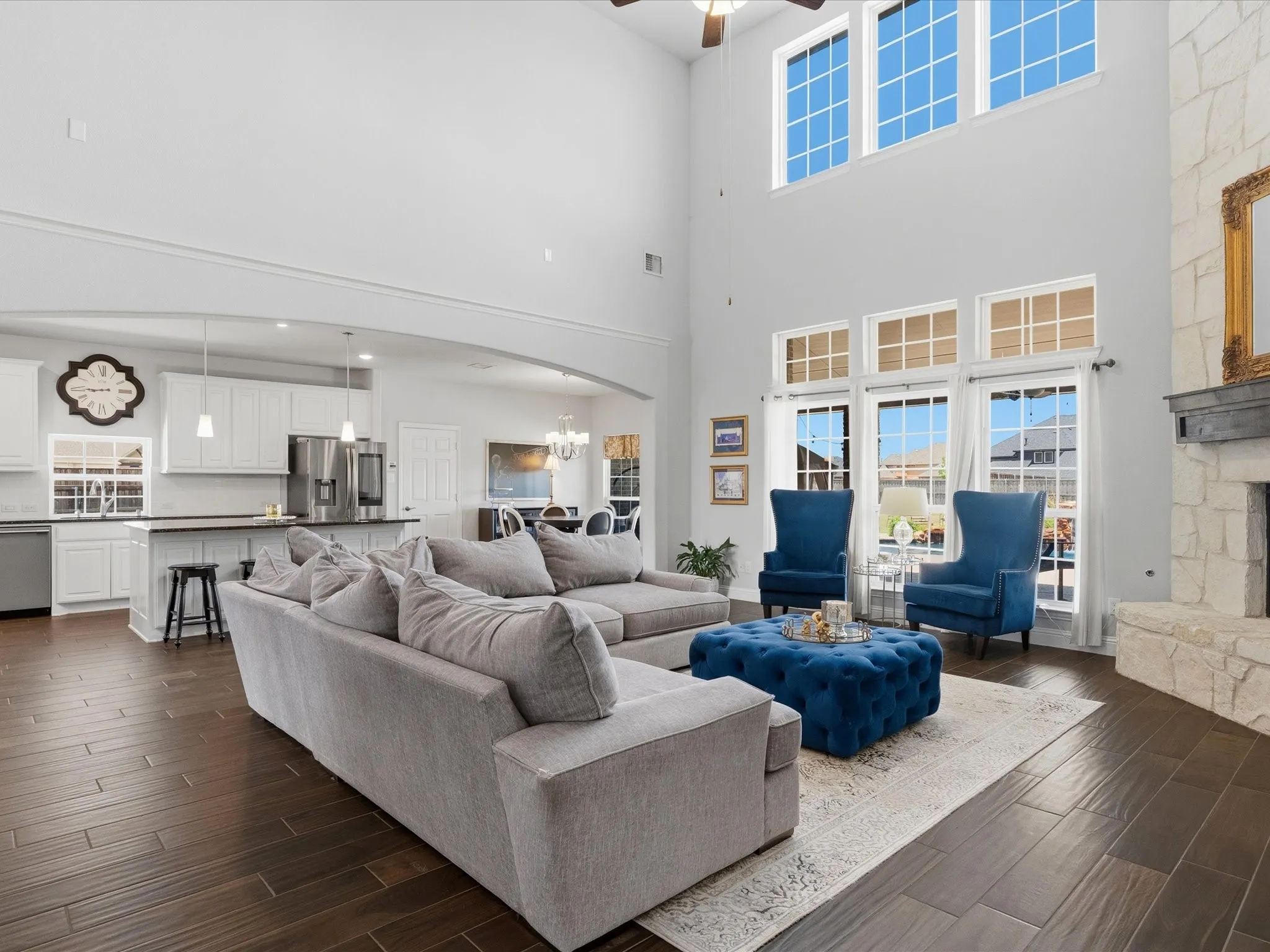 Open floor plan with vaulted ceilings and view of sparkling pool and oversized back yard.