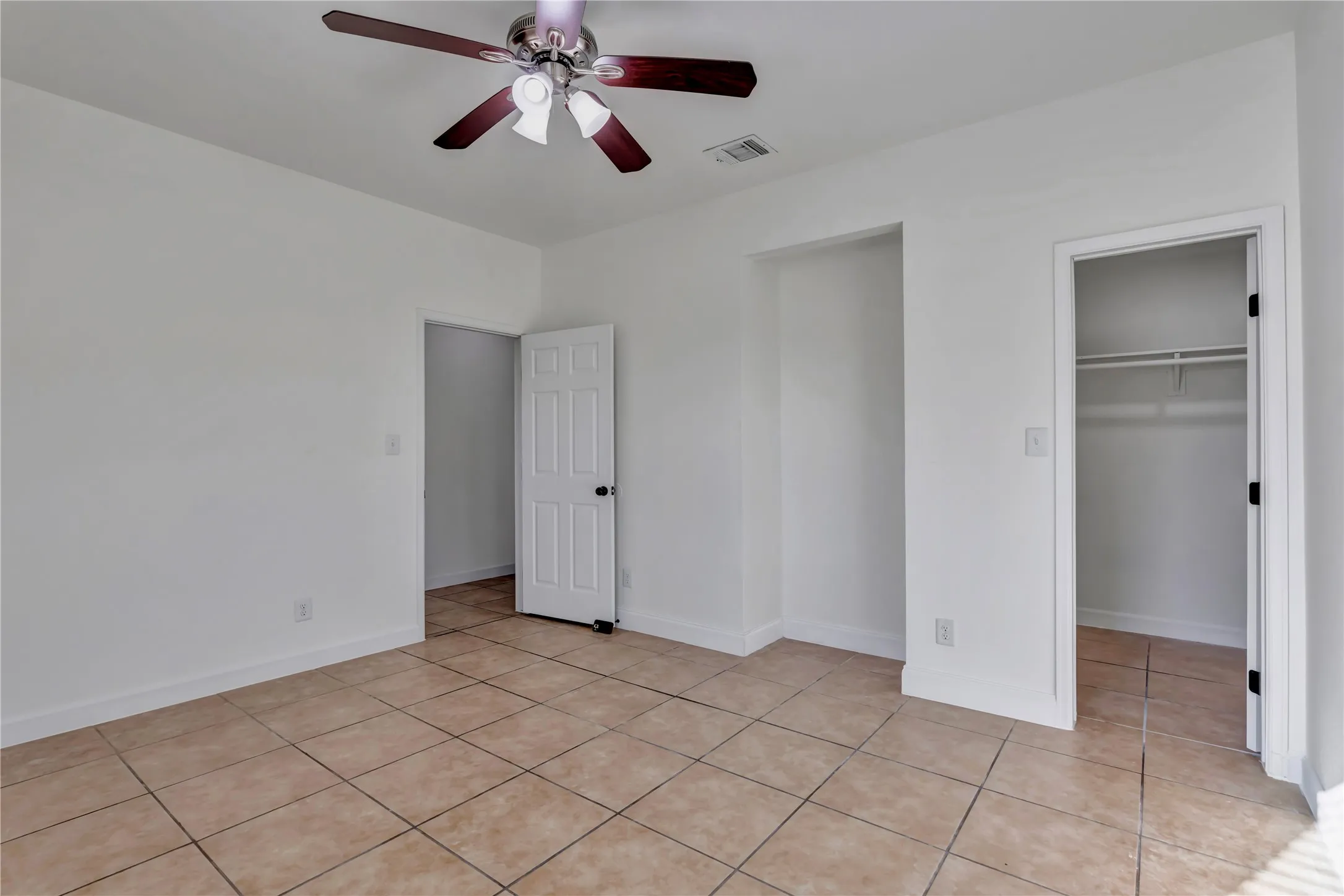 Interior room with square tile flooring, white walls, and white baseboards