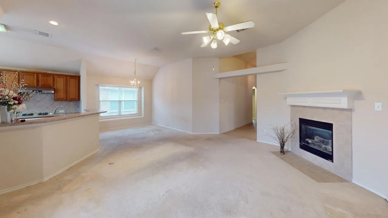 Living area featuring a fireplace with a light-colored tile surround and a classic white mantel
