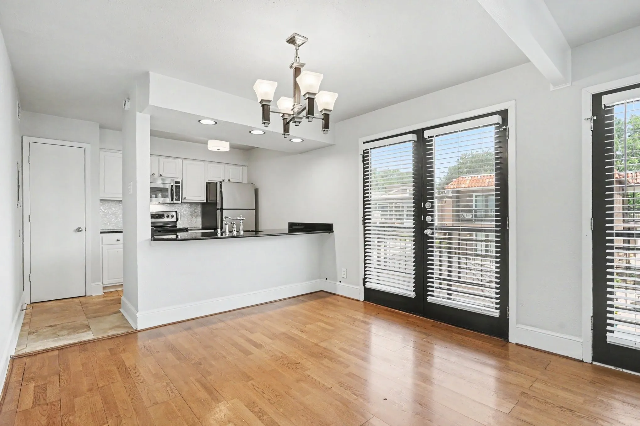 The dining area is open to the kitchen and has an attractive leather-trimmed chandelier.