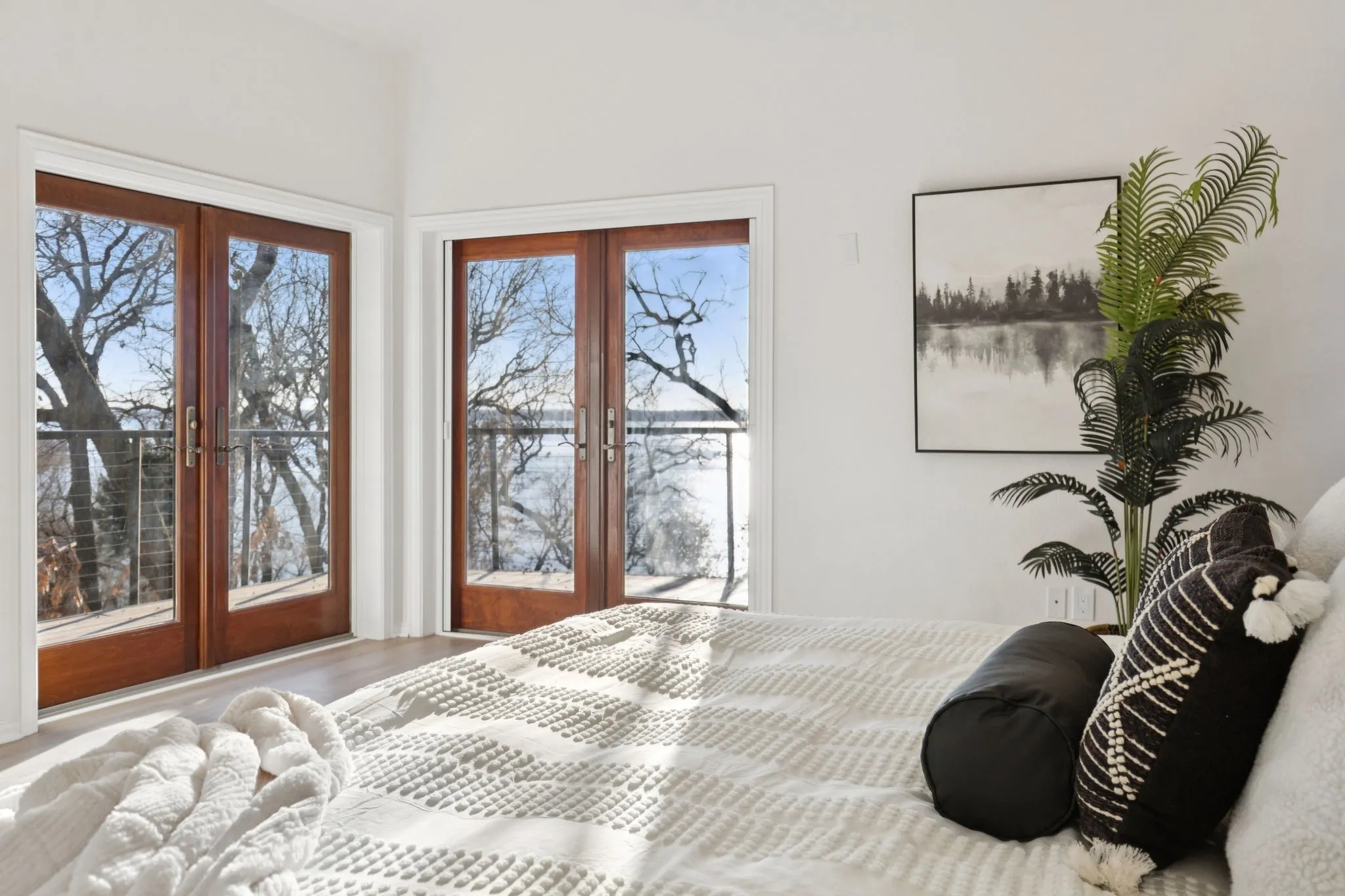 Bedroom with multiple windows, french doors, access to outside, and wood finished floors