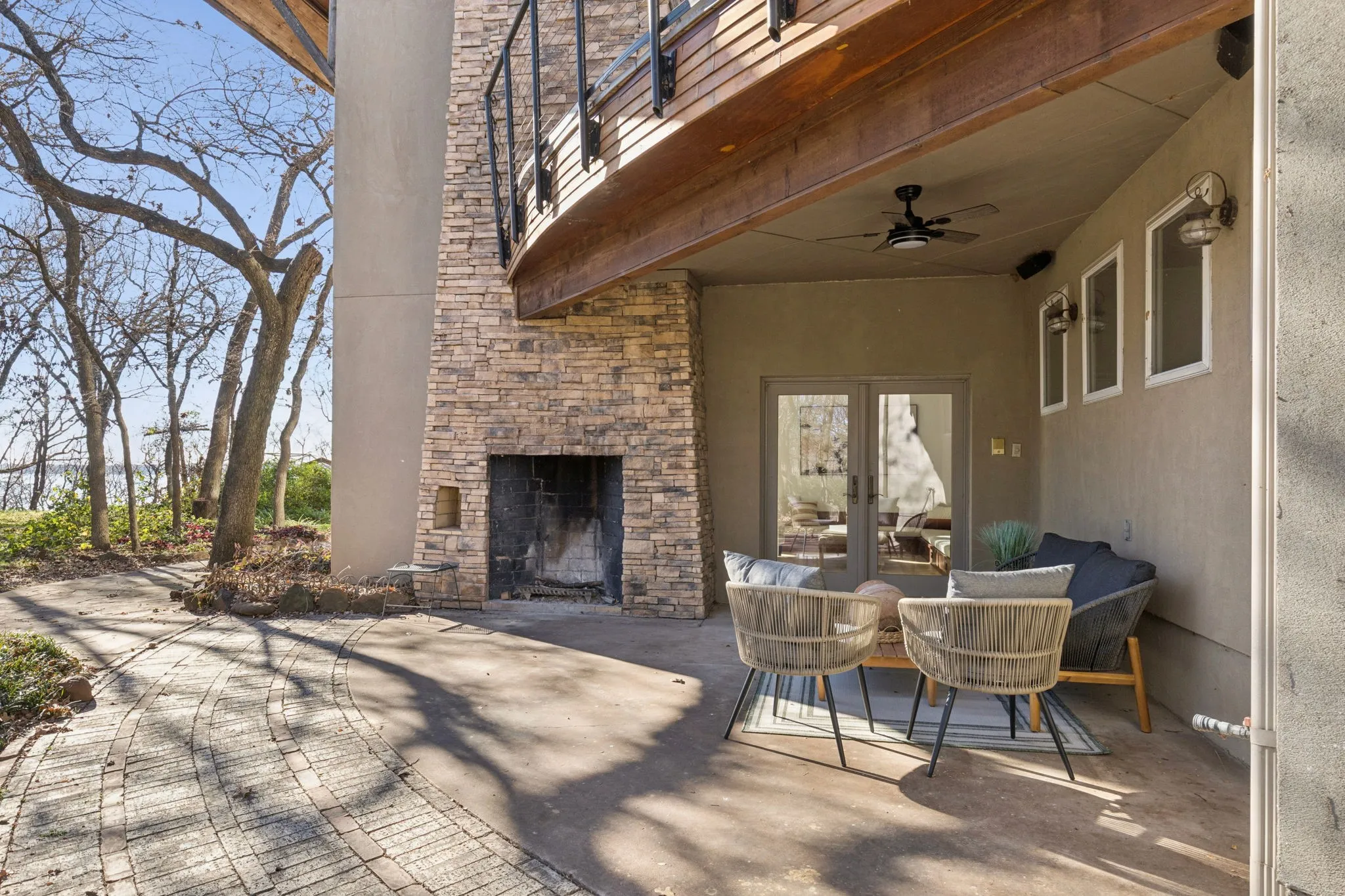 View of patio / terrace with an outdoor stone fireplace, french doors, and ceiling fan