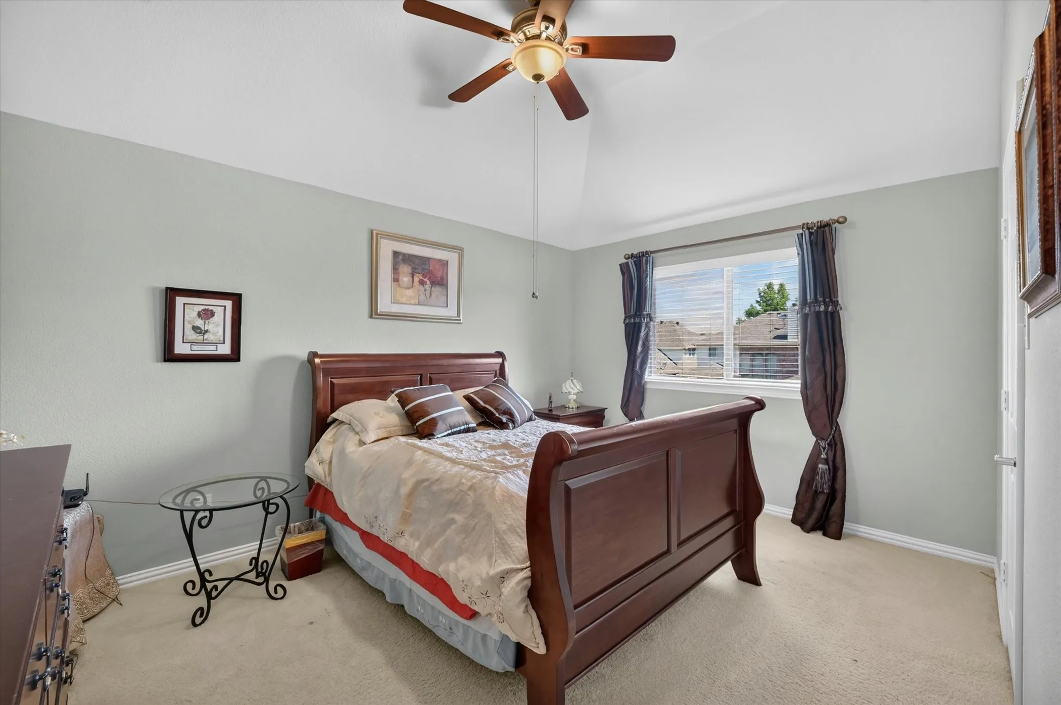 Carpeted bedroom with a ceiling fan, window blinds, and light-colored walls