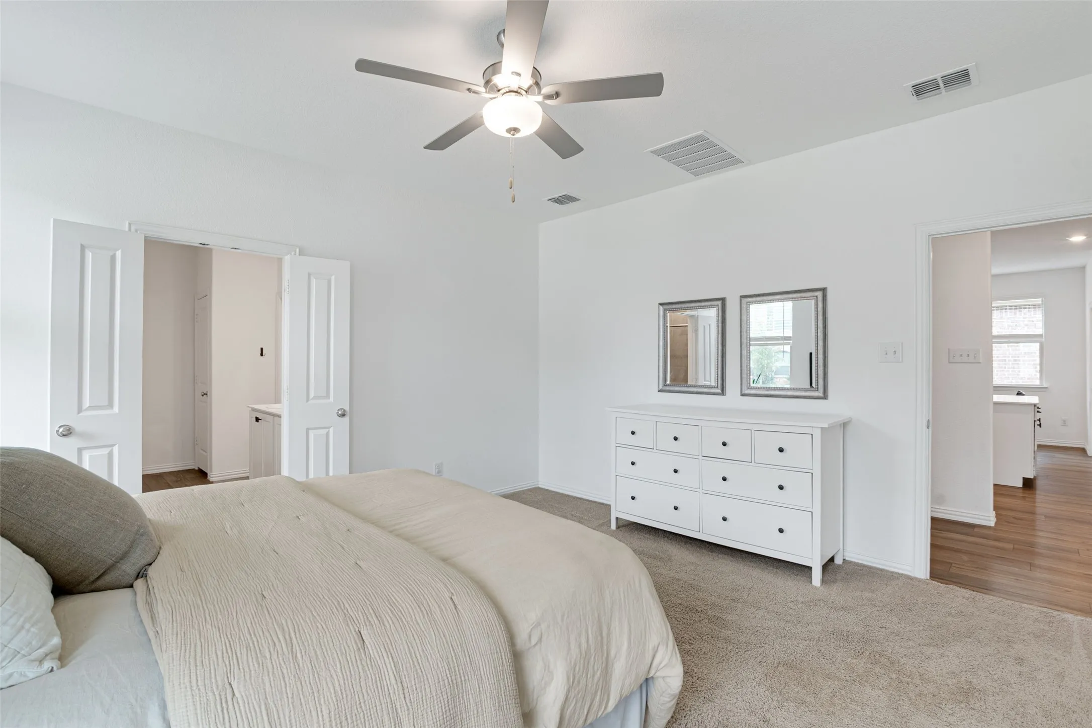 Carpeted bedroom featuring a ceiling fan with integrated lighting, white walls, and a recessed closet with double panel doors