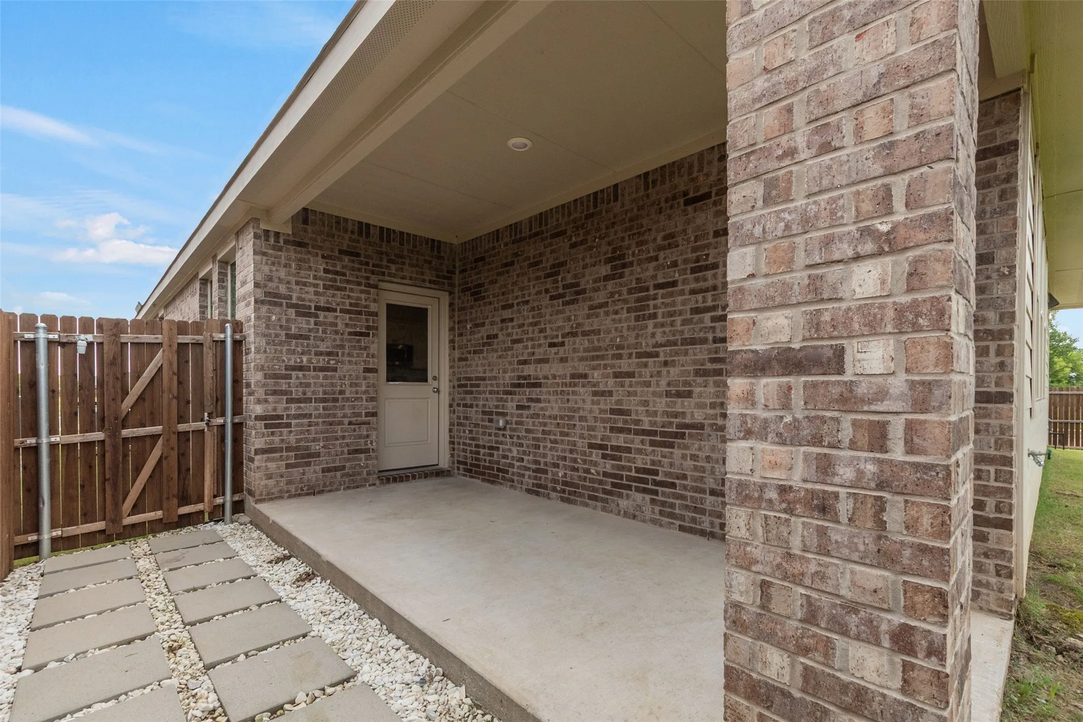 Covered patio featuring brick masonry and a concrete surface