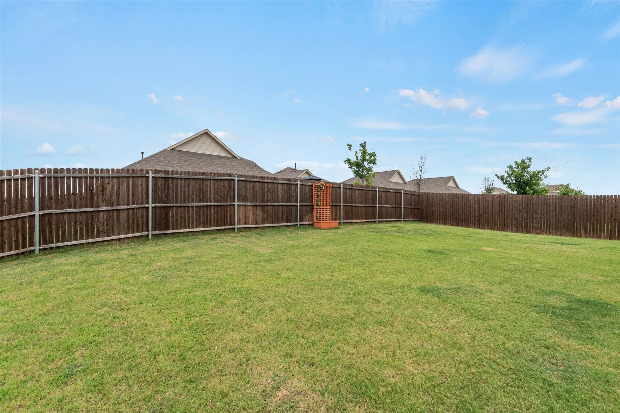 Expansive grassy yard with a full privacy fence