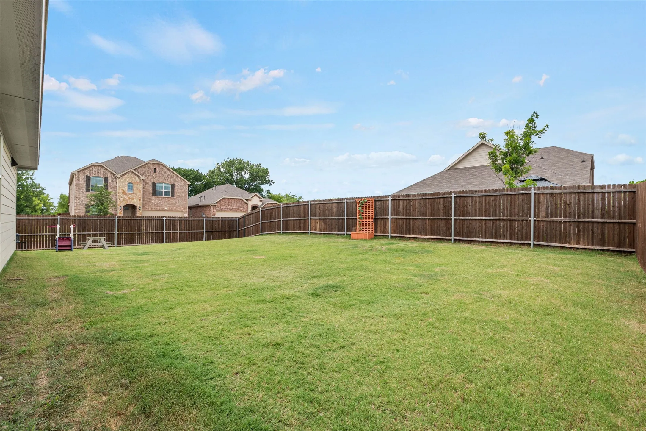 Expansive backyard featuring a manicured lawn and a full privacy​​‌​​​​‌​​‌‌​‌‌​​​‌‌​‌​‌​‌​​​‌​​ fence