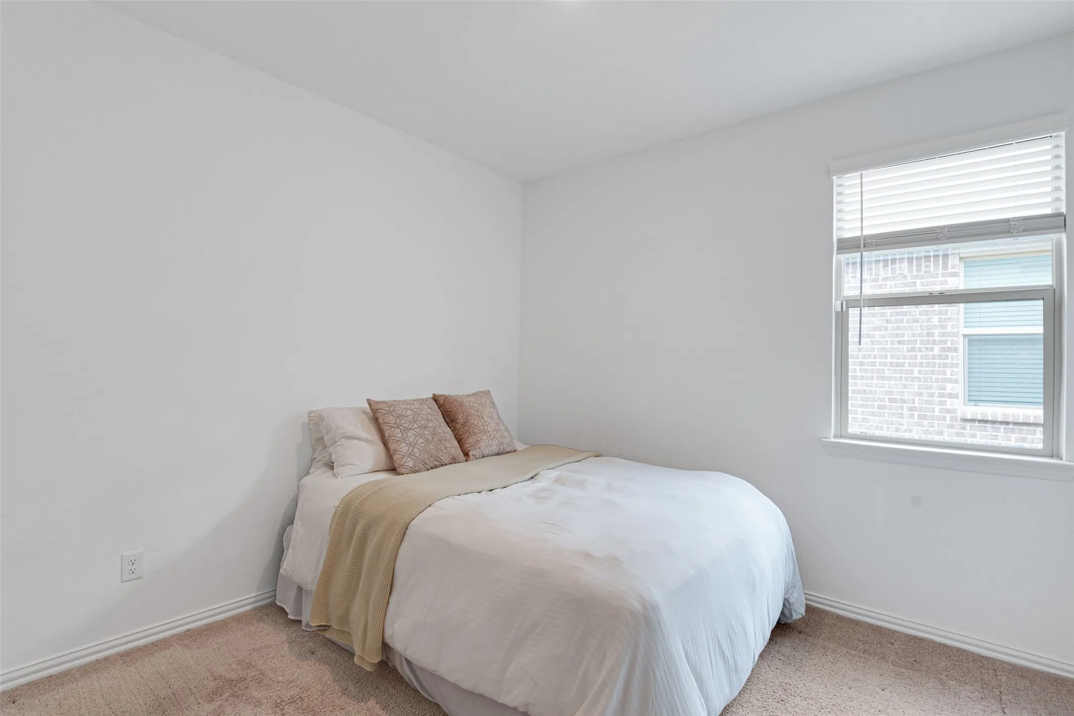Carpeted room with white walls, a single window featuring white blinds, and a white baseboard trim