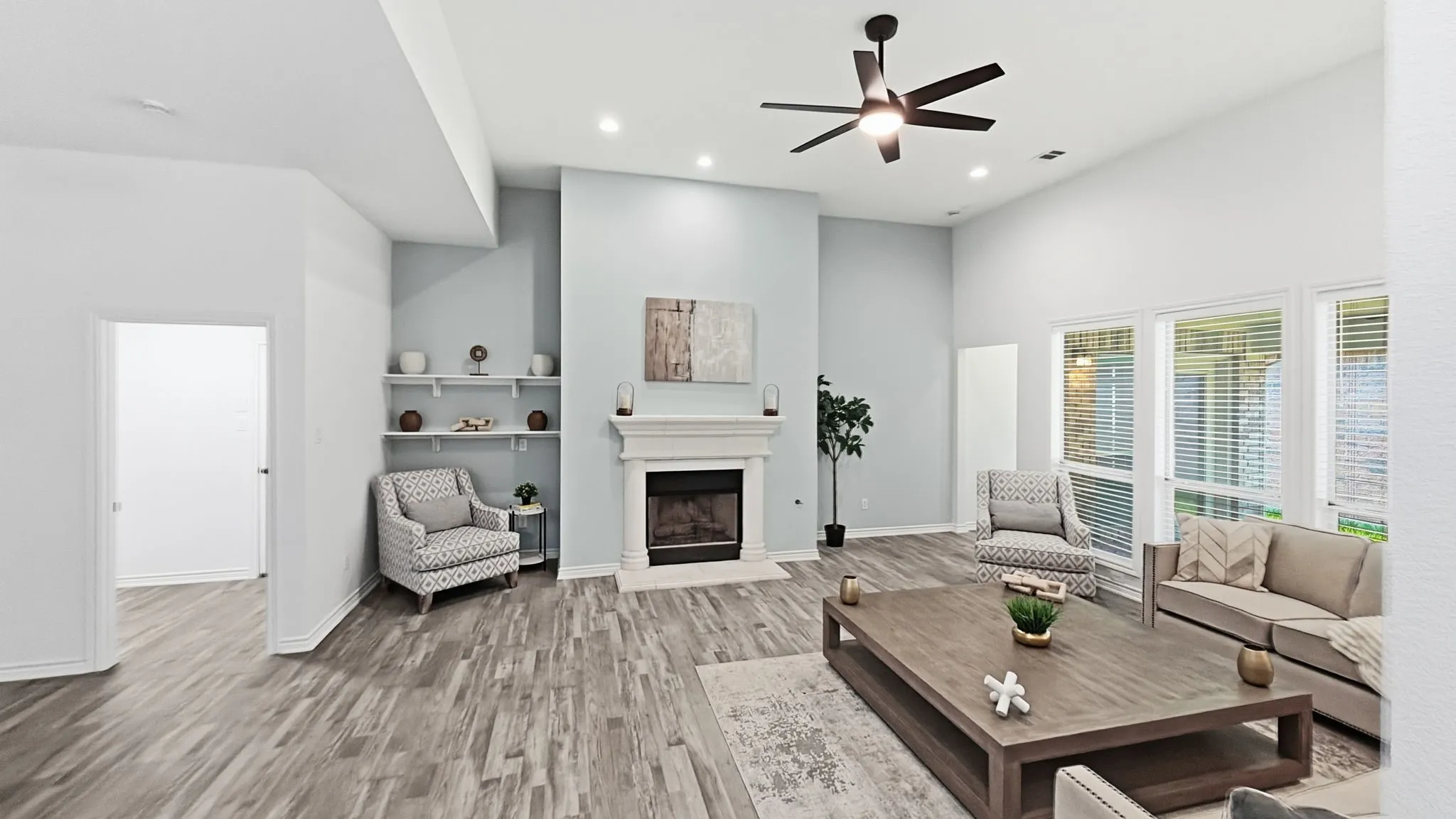 Vaulted ceilings, wood-finish flooring, recessed lighting, built-in shelving, and a fireplace with a mantel