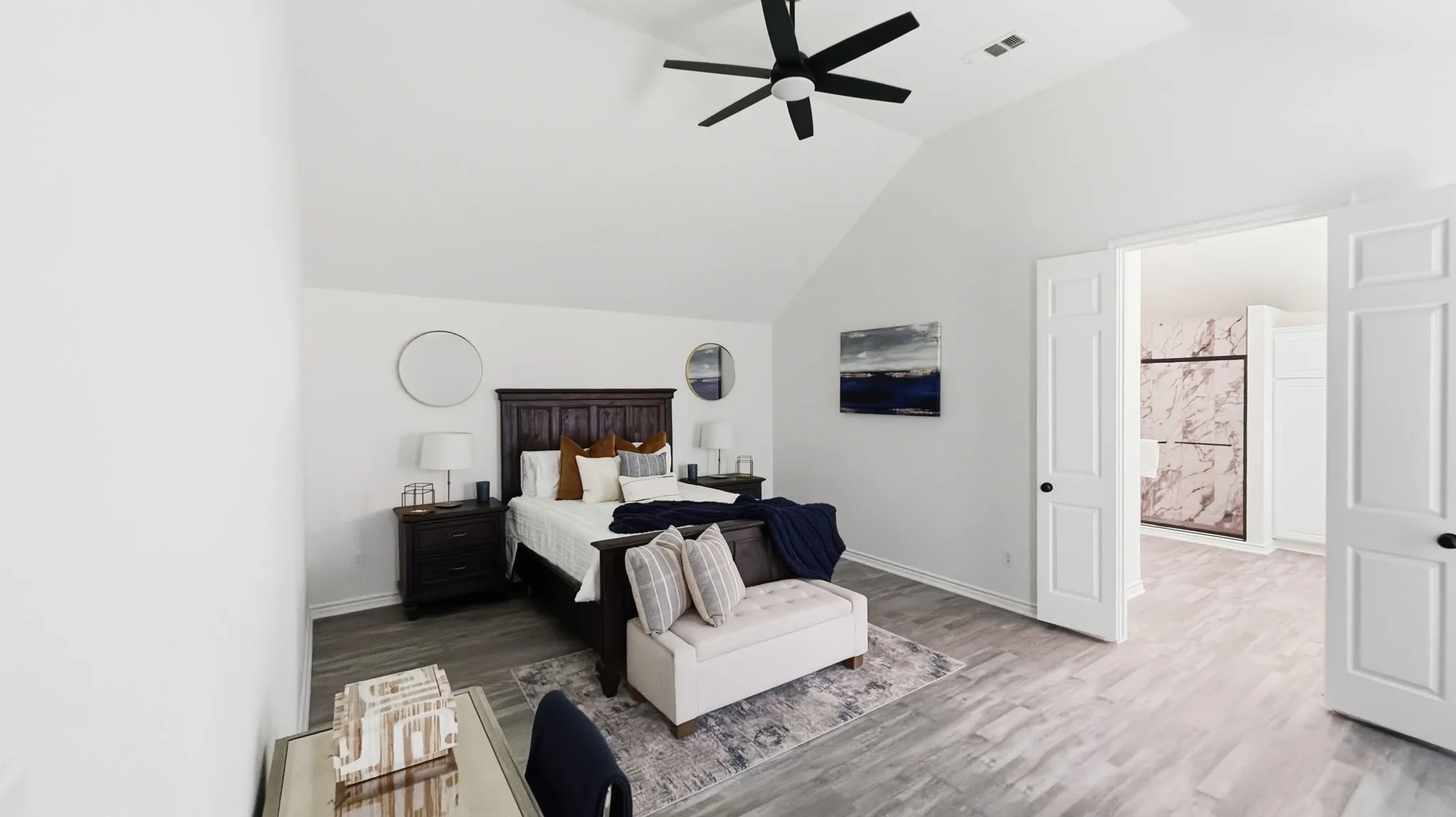 Vaulted ceiling with a black ceiling fan, wood-finish flooring, and white paneled doors