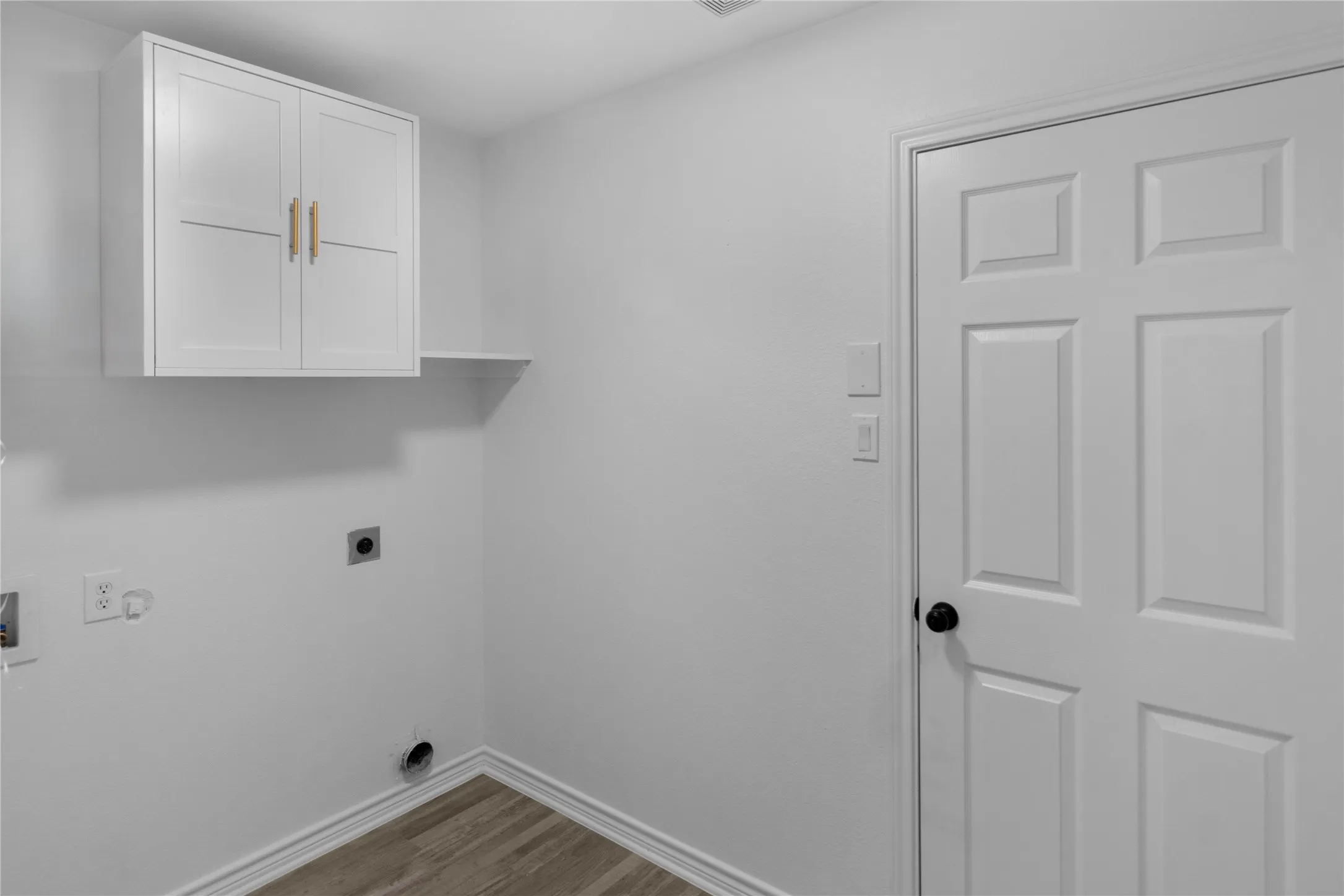 White overhead cabinetry featuring a coordinating white shelf