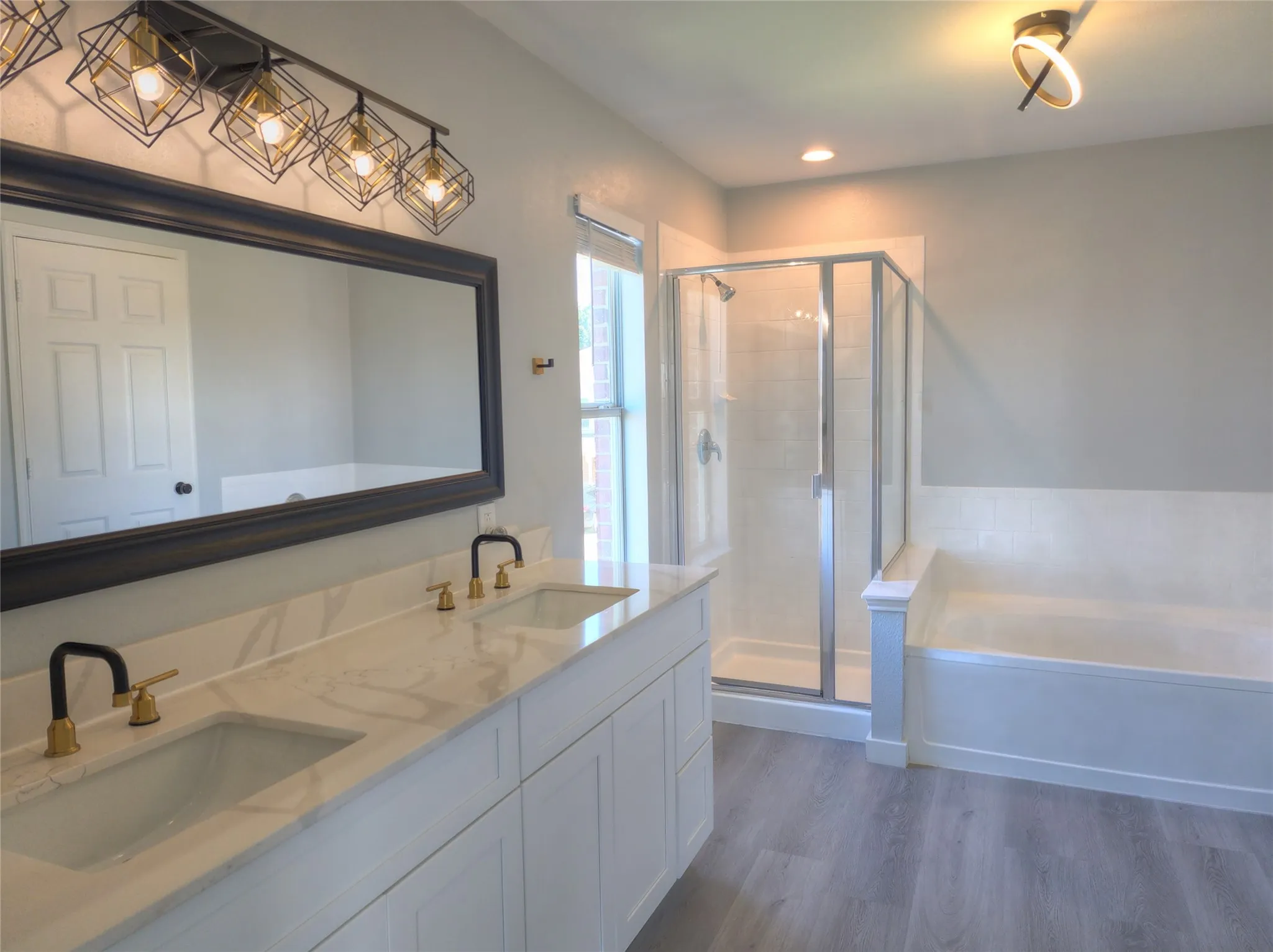 Bathroom featuring a double vanity with stone countertops, undermount sinks, and two-tone faucets