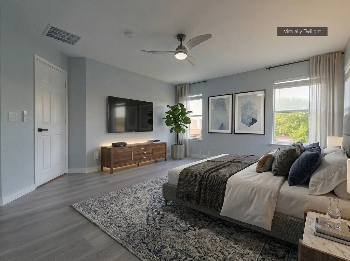 Spacious bedroom featuring wood-finish flooring, a contemporary ceiling fan, and multiple windows providing ample natural light