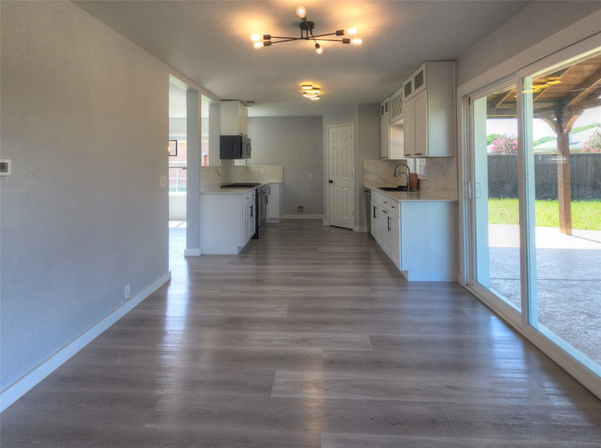 Spacious room featuring wood-finish flooring and light gray walls