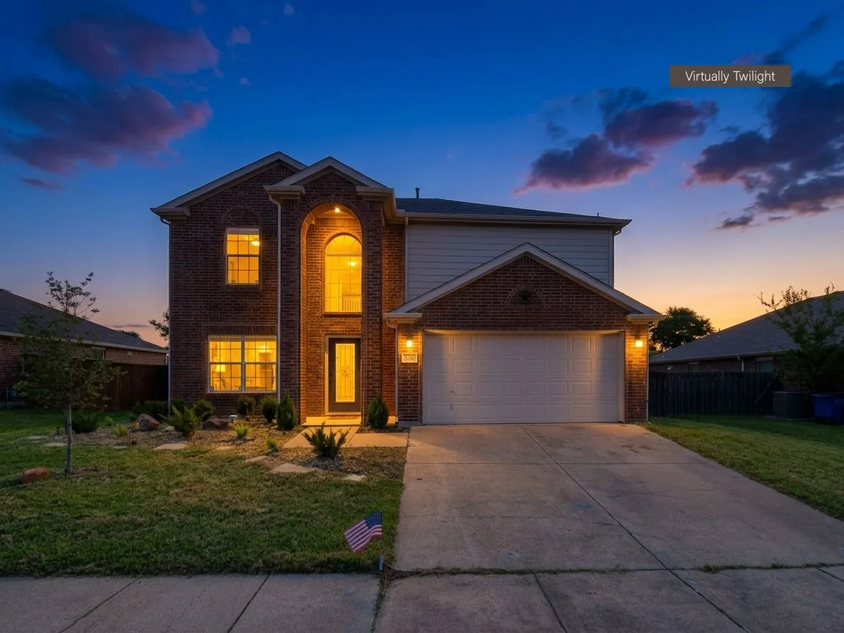 Brick and siding exterior featuring an arched entryway, multiple windows, a two-car garage, and a concrete driveway
