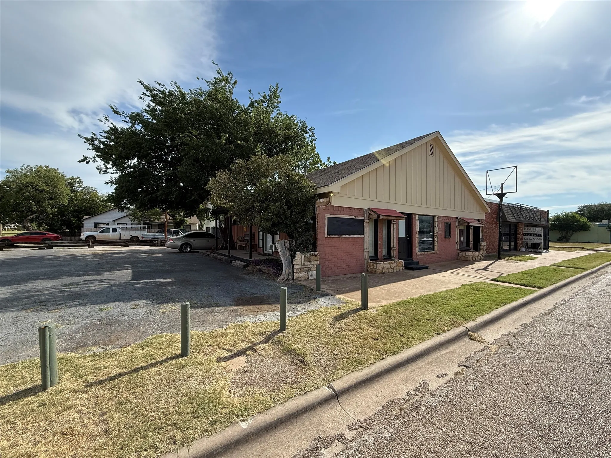 Commercial building featuring a gabled roofline, brick facade, and an awning over the entrance
