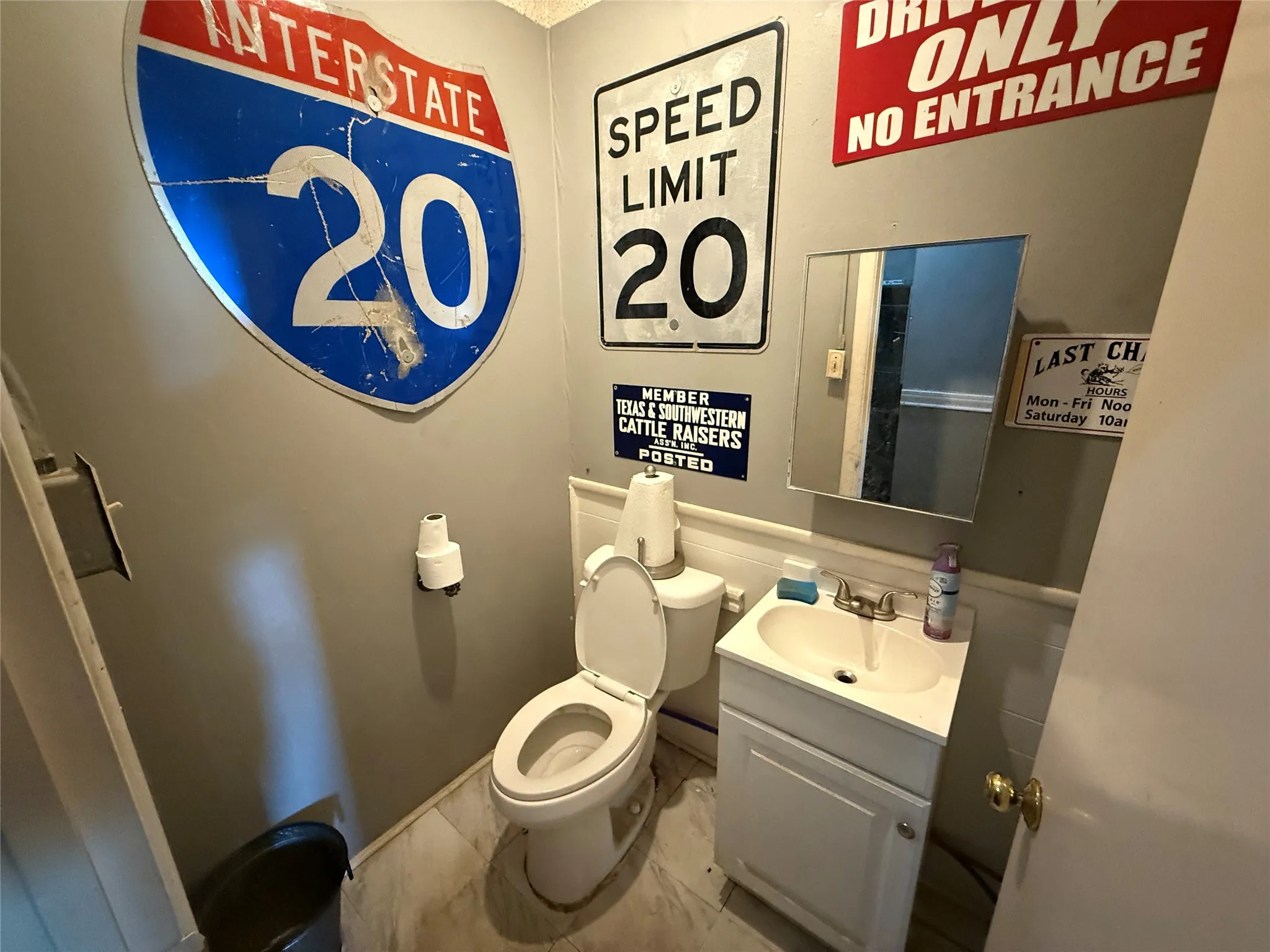Bathroom featuring a white toilet, single vanity with integrated sink, and wall-mounted mirror