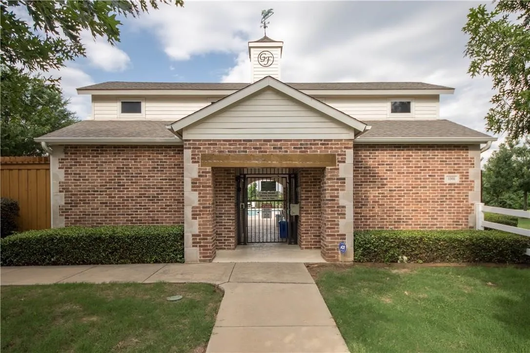 Brick and siding building featuring a prominent gabled entrance with an ornamental​​‌​​​​‌​​‌‌​‌‌​​​‌‌​‌​‌​‌​​​‌​​ weathervane