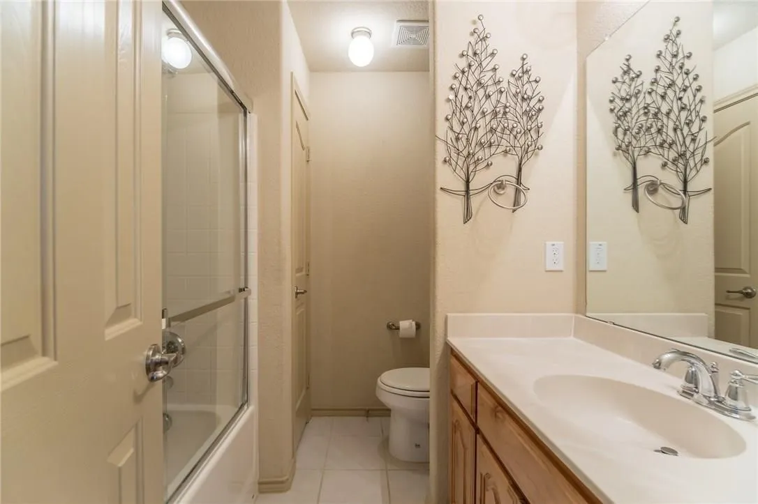 Bathroom featuring a single vanity with wood cabinetry, an integrated sink, and a chrome faucet