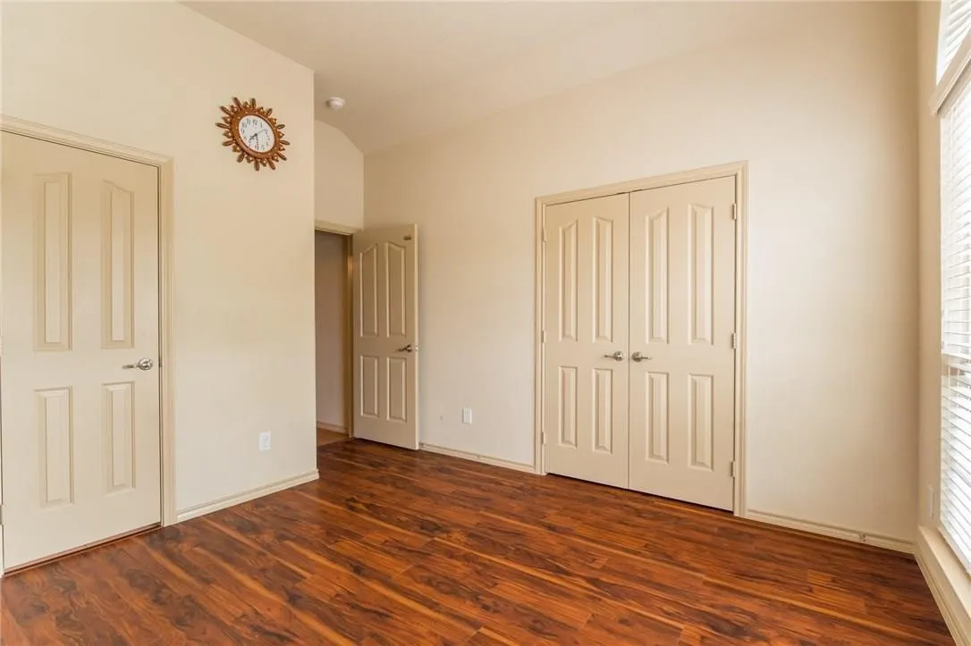 Interior room featuring wood-finish flooring, light neutral wall paint, and multiple panel doors