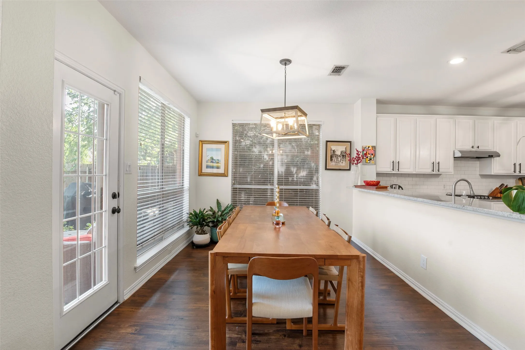 Open-concept dining area featuring wood-finish flooring and multiple windows