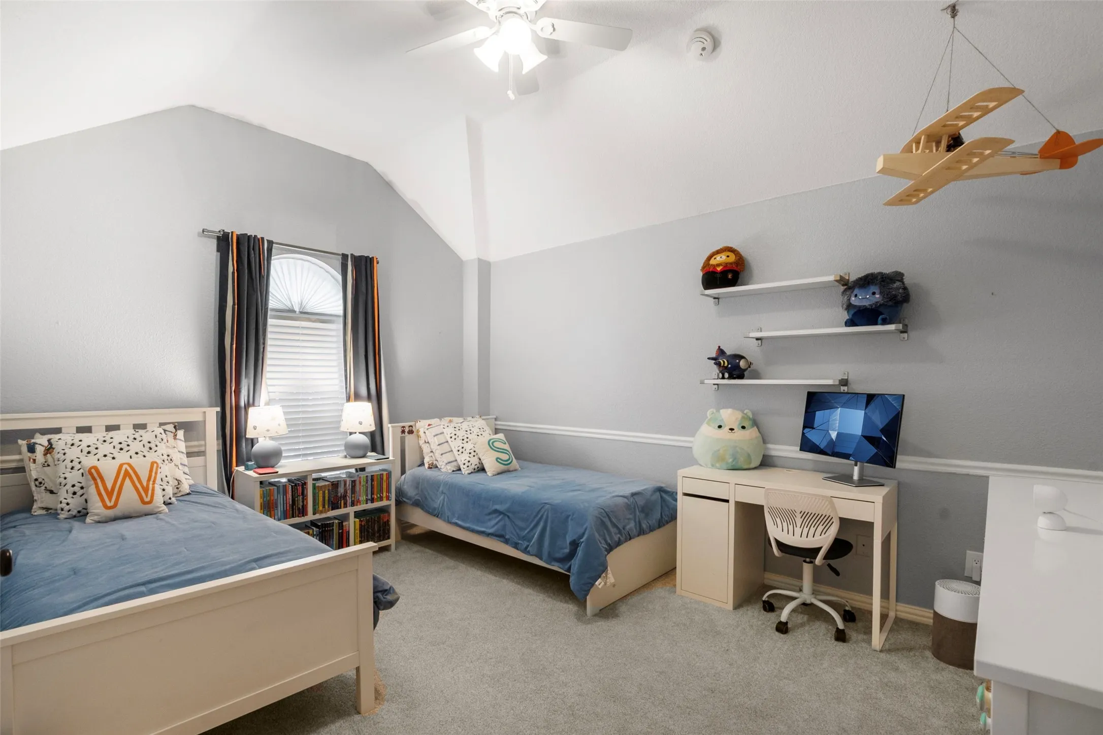 Vaulted ceiling bedroom featuring carpeting, a white ceiling fan, and a window with blinds and dark drapery