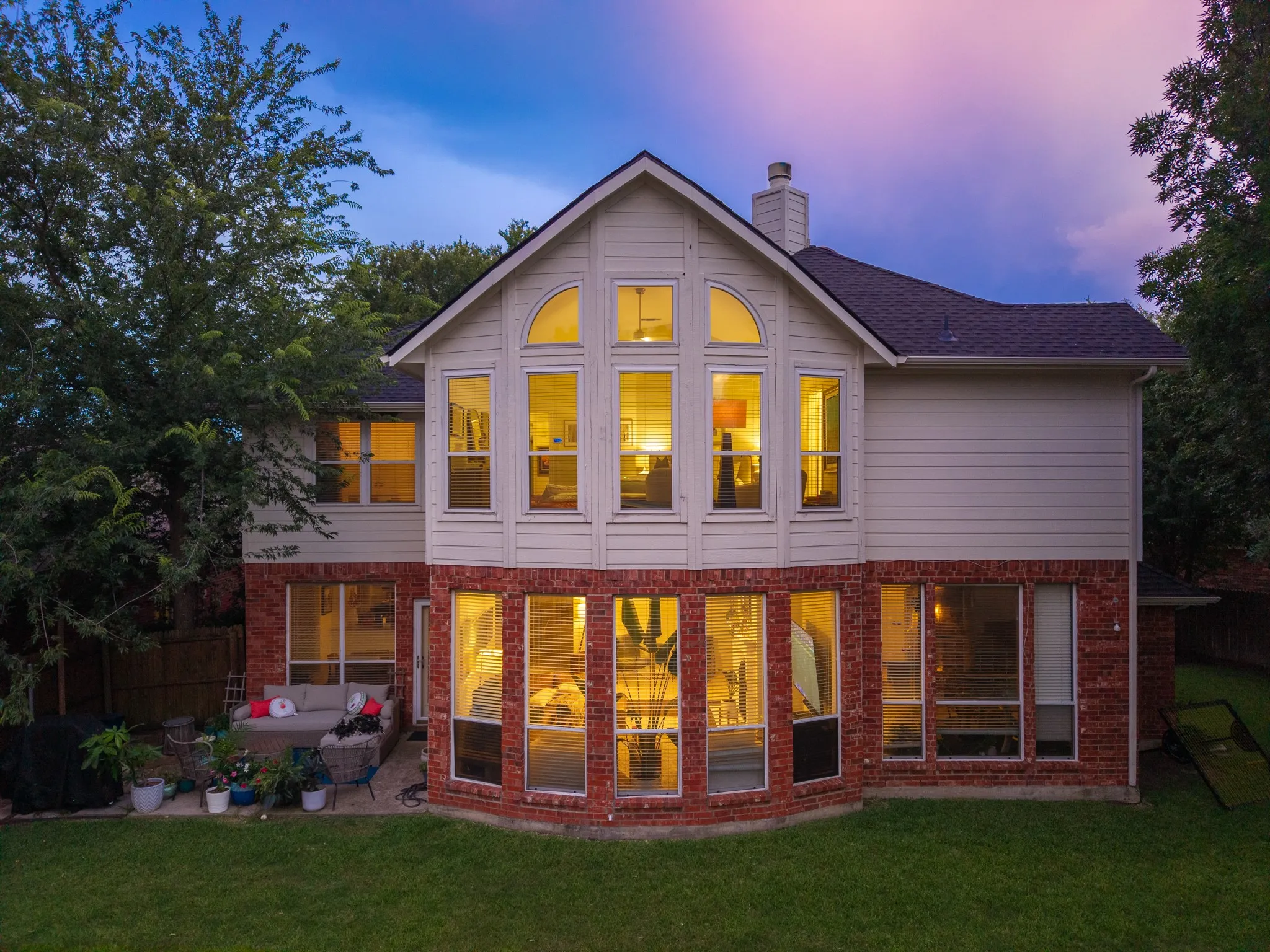 Two-story residence featuring a prominent bay window with brick and siding exterior