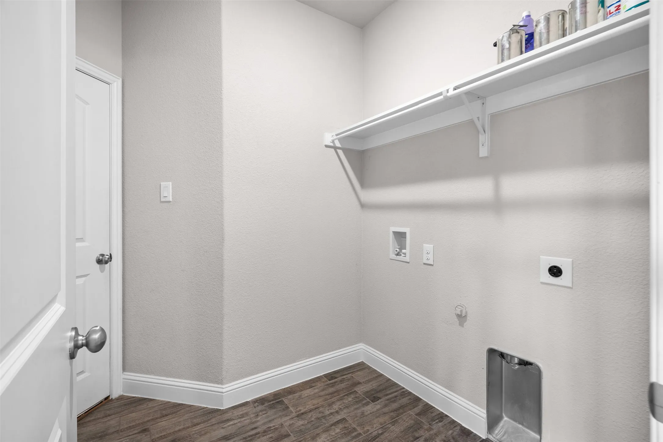 Dedicated utility space featuring wood-look tile flooring, white baseboards, and light gray walls