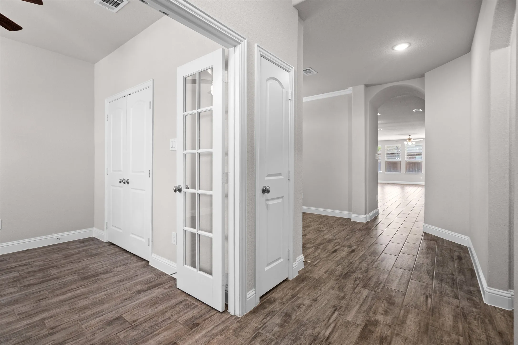 French doors opening to a versatile room with wood-finish flooring