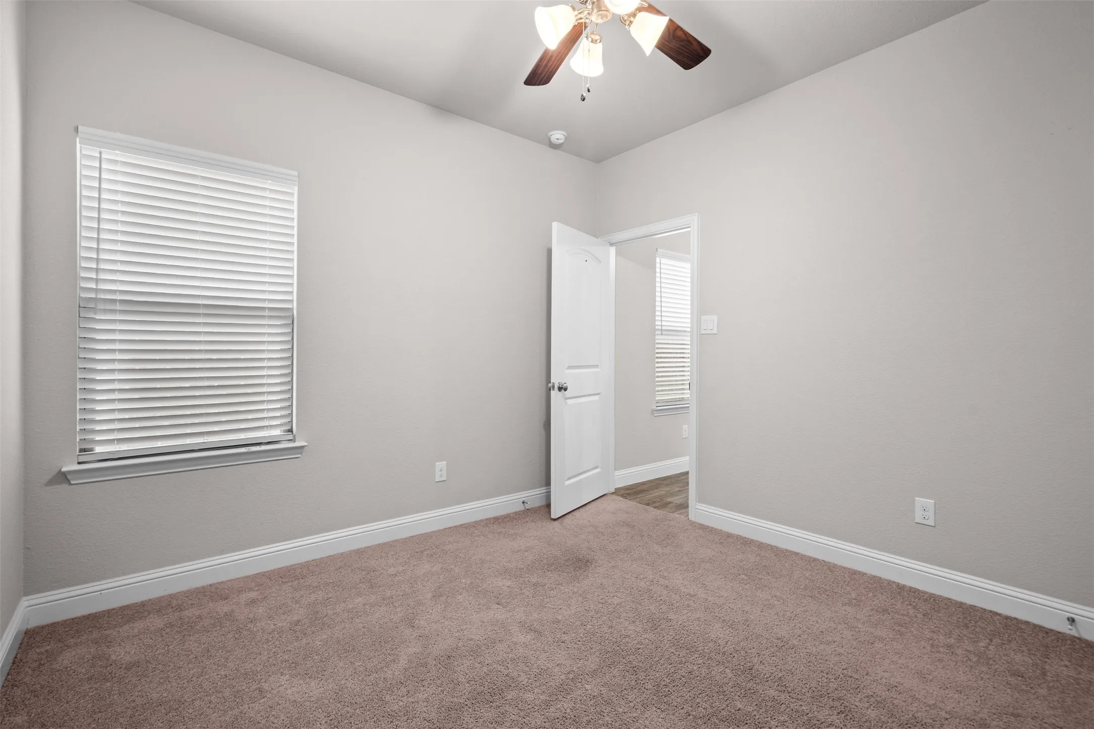Interior room featuring light gray walls, brown carpet flooring, and white trim