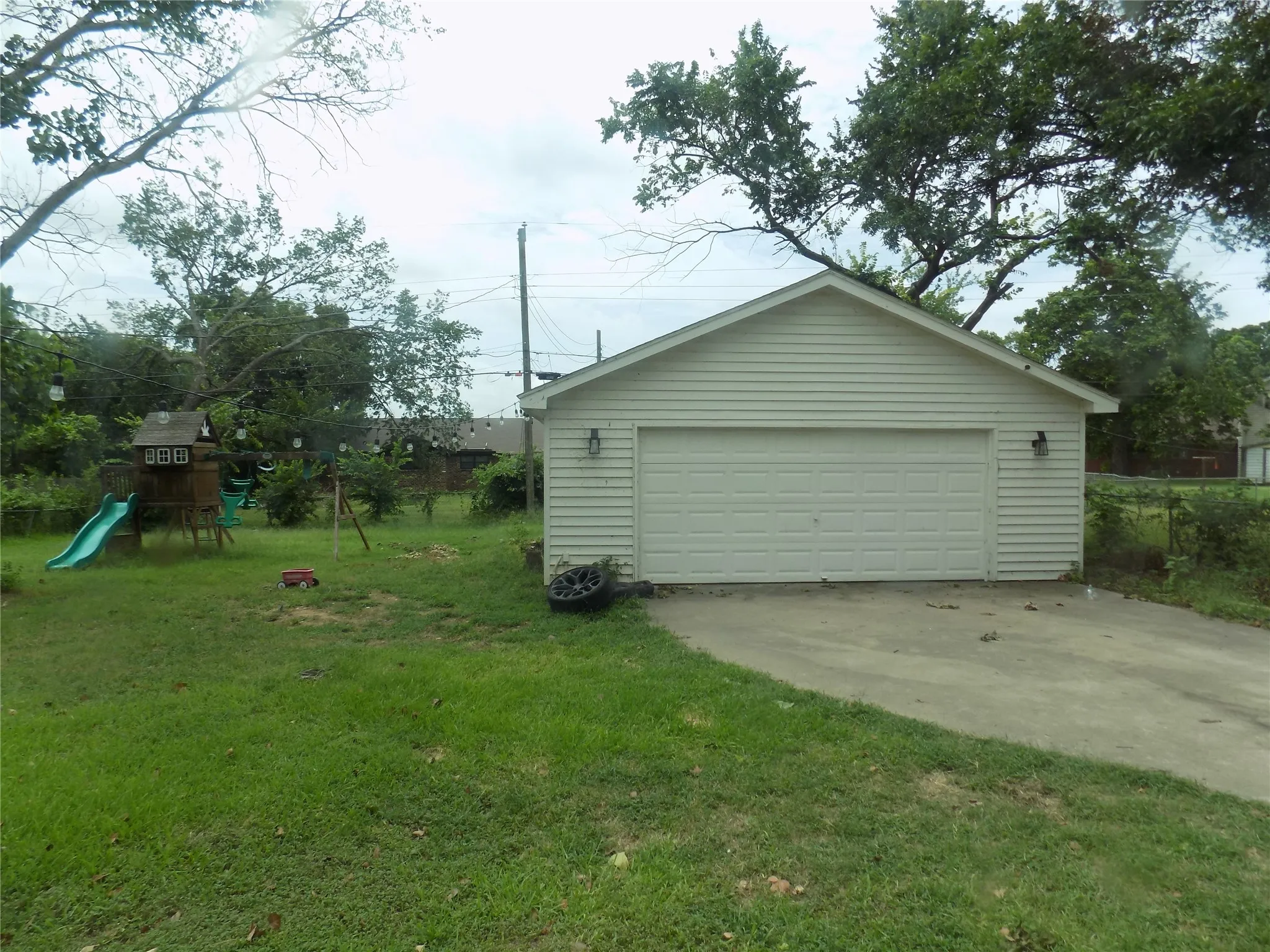 Large yard with swing set and garage.